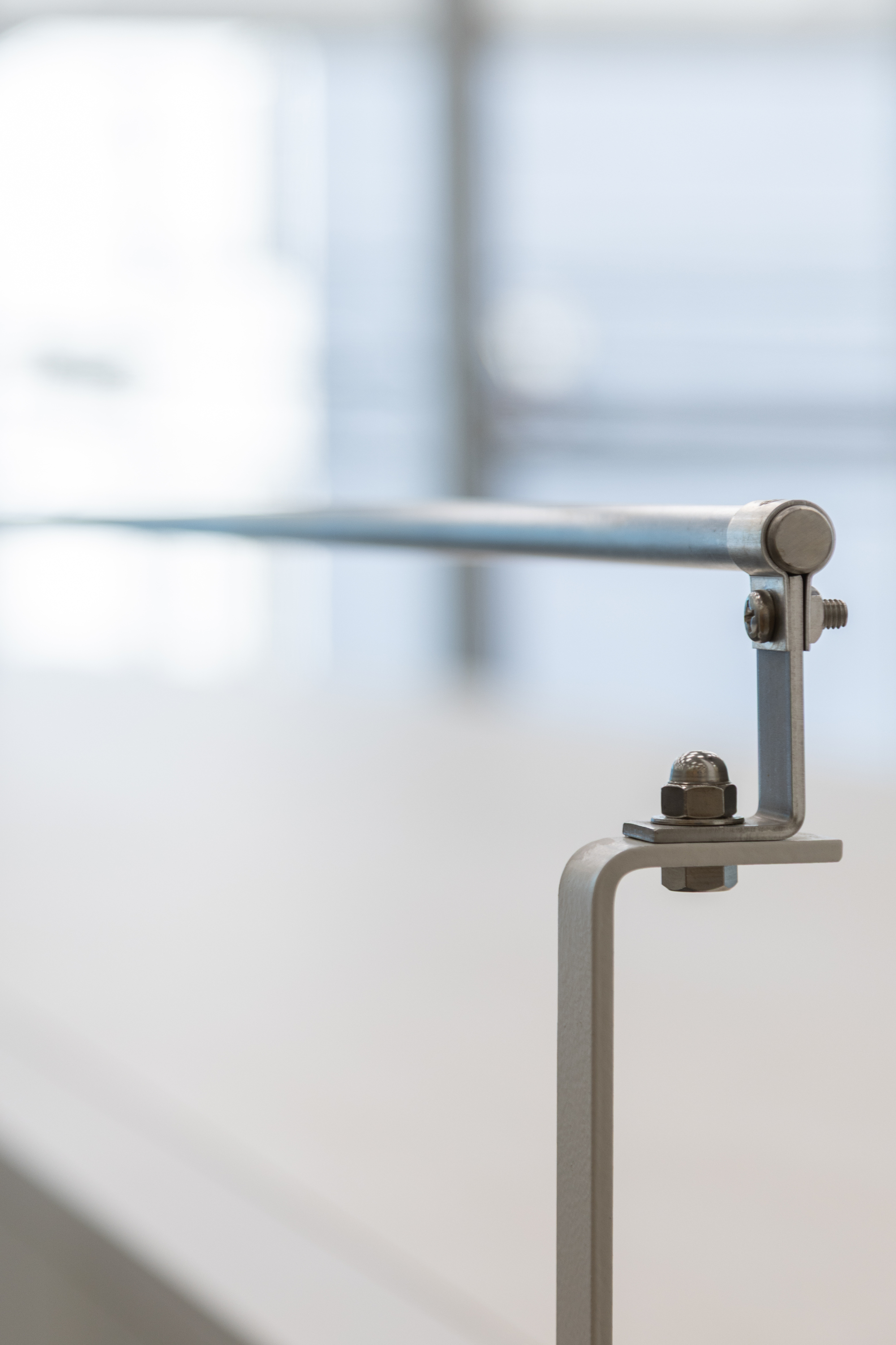 Close-up of steel rod joint with threaded bolt connections in soft natural light