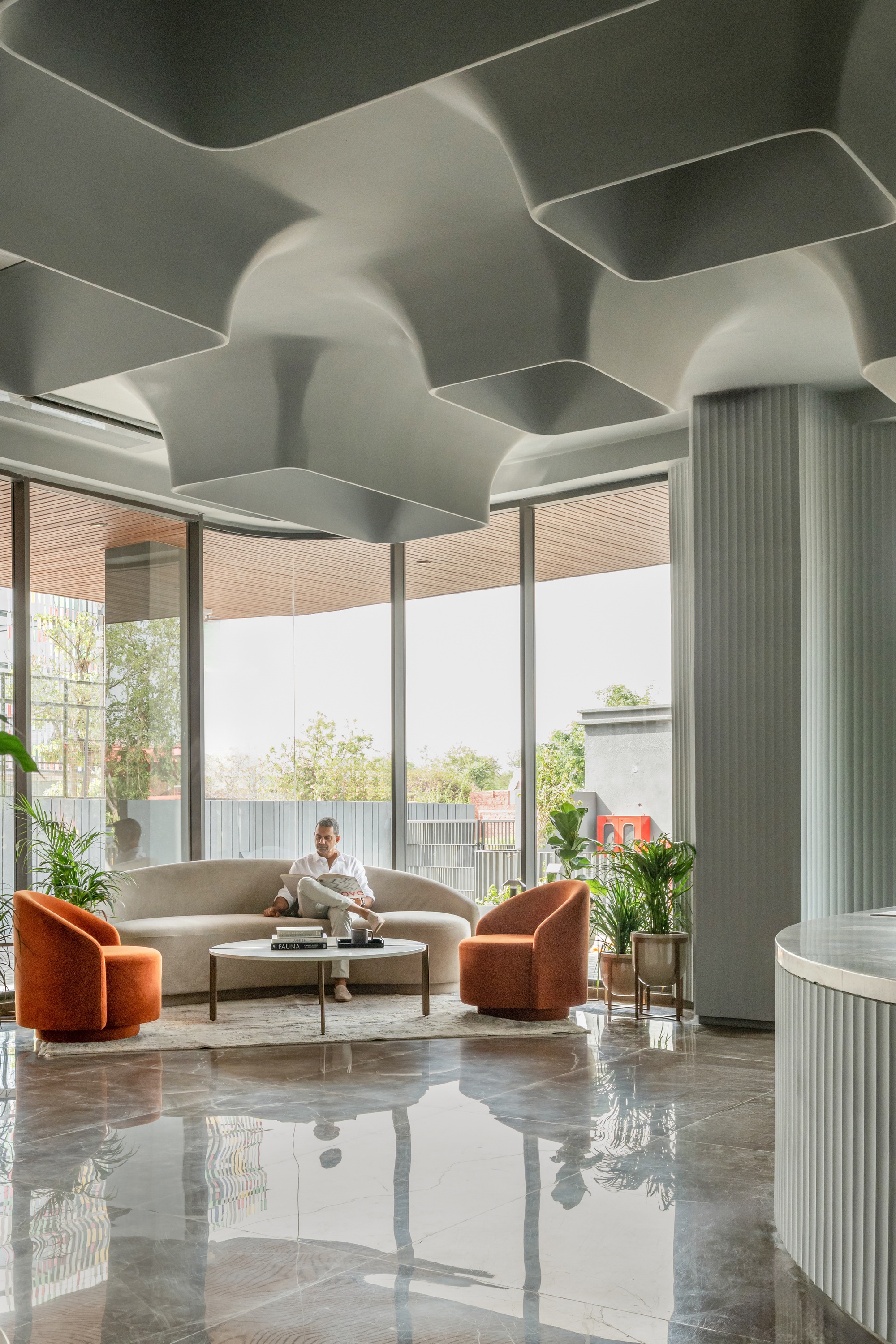 Lobby interior with sculpted white ceiling coffers and fluted columns beside polished stone floor