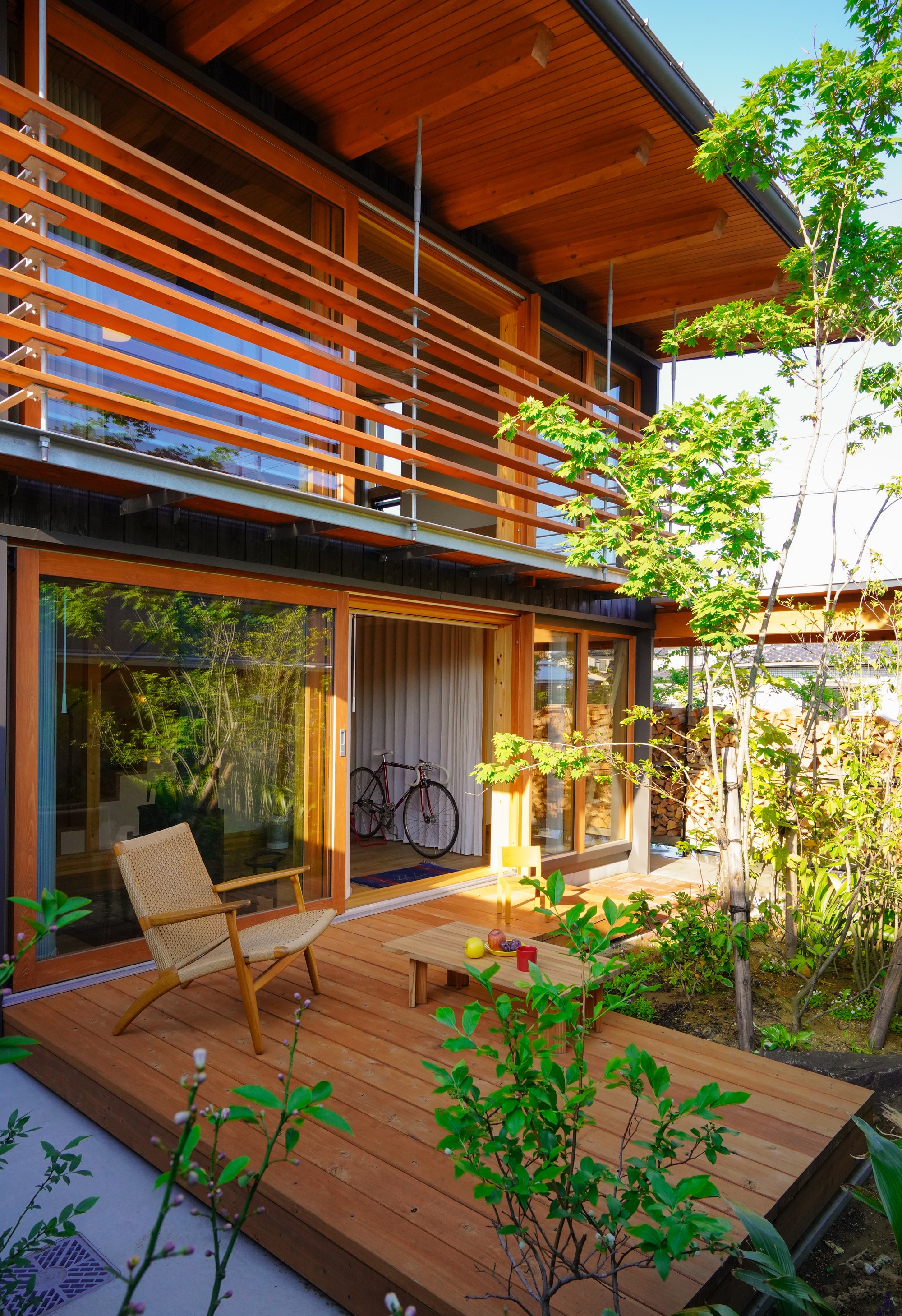 Timber deck with horizontal wood slat screen and glass doors opening to planted garden