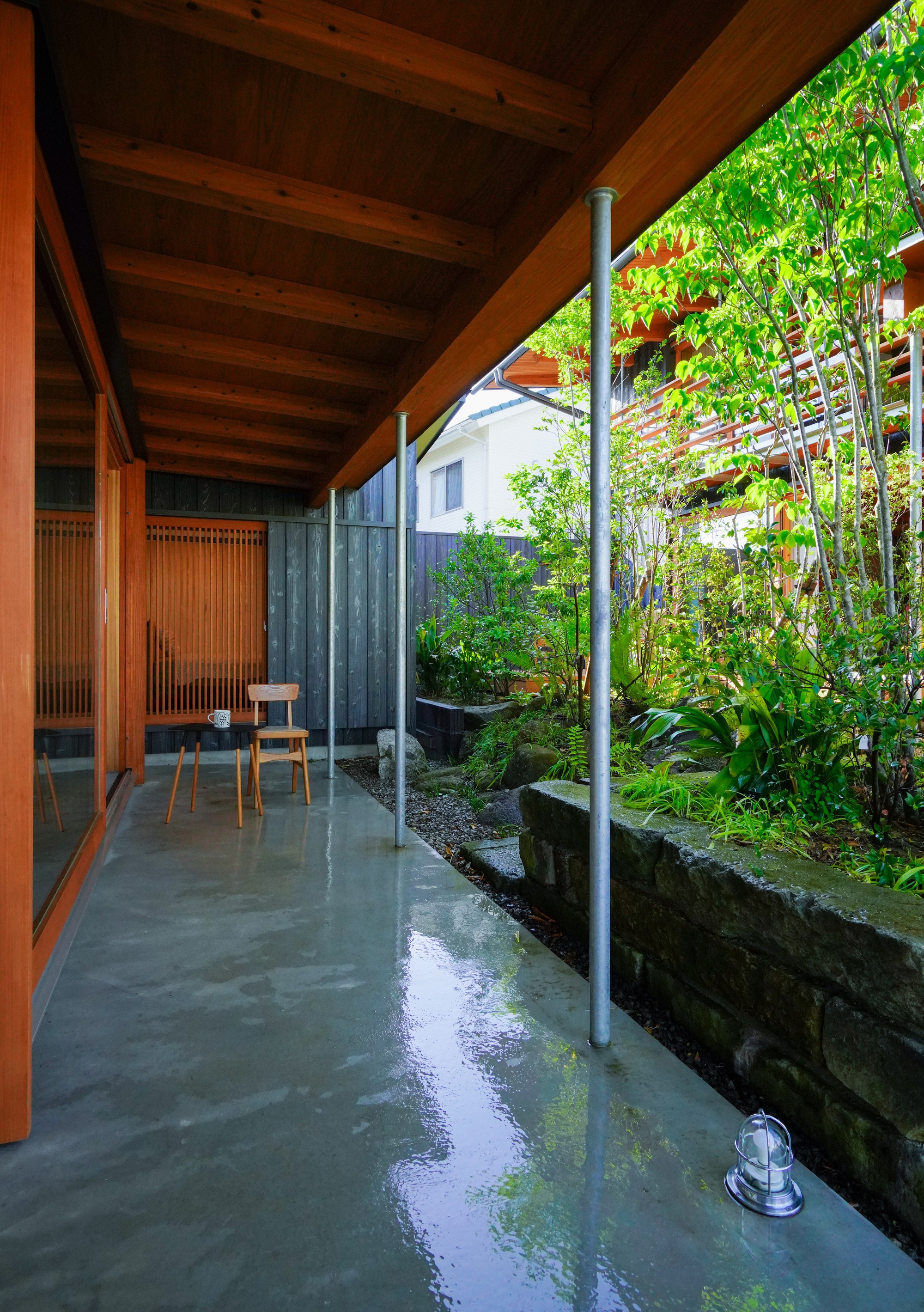 Covered terrace with polished concrete floor and vertical planted wall along the edge
