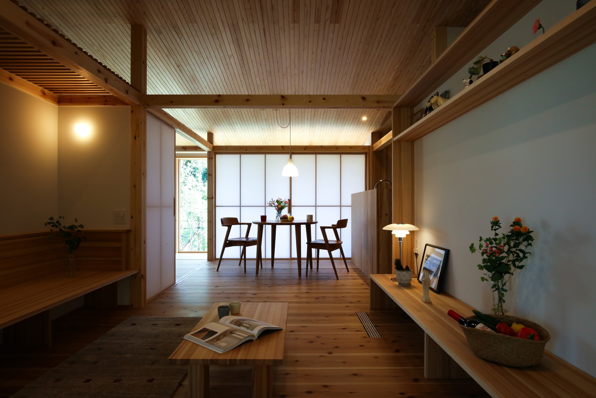 Interior view through timber framed rooms toward shoji screen dining area with pendant light