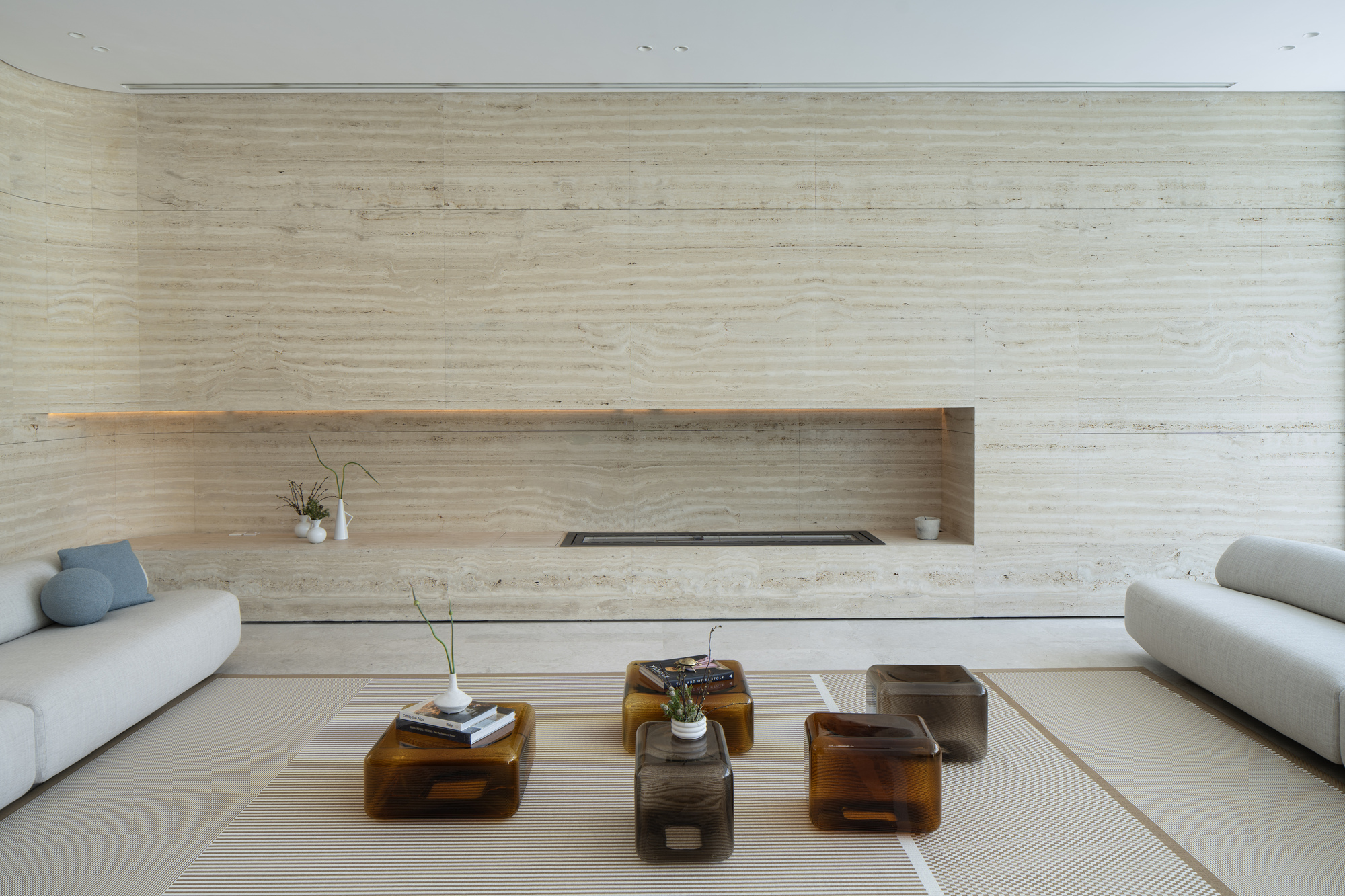 Travertine feature wall with horizontal recessed niche and floating timber shelf