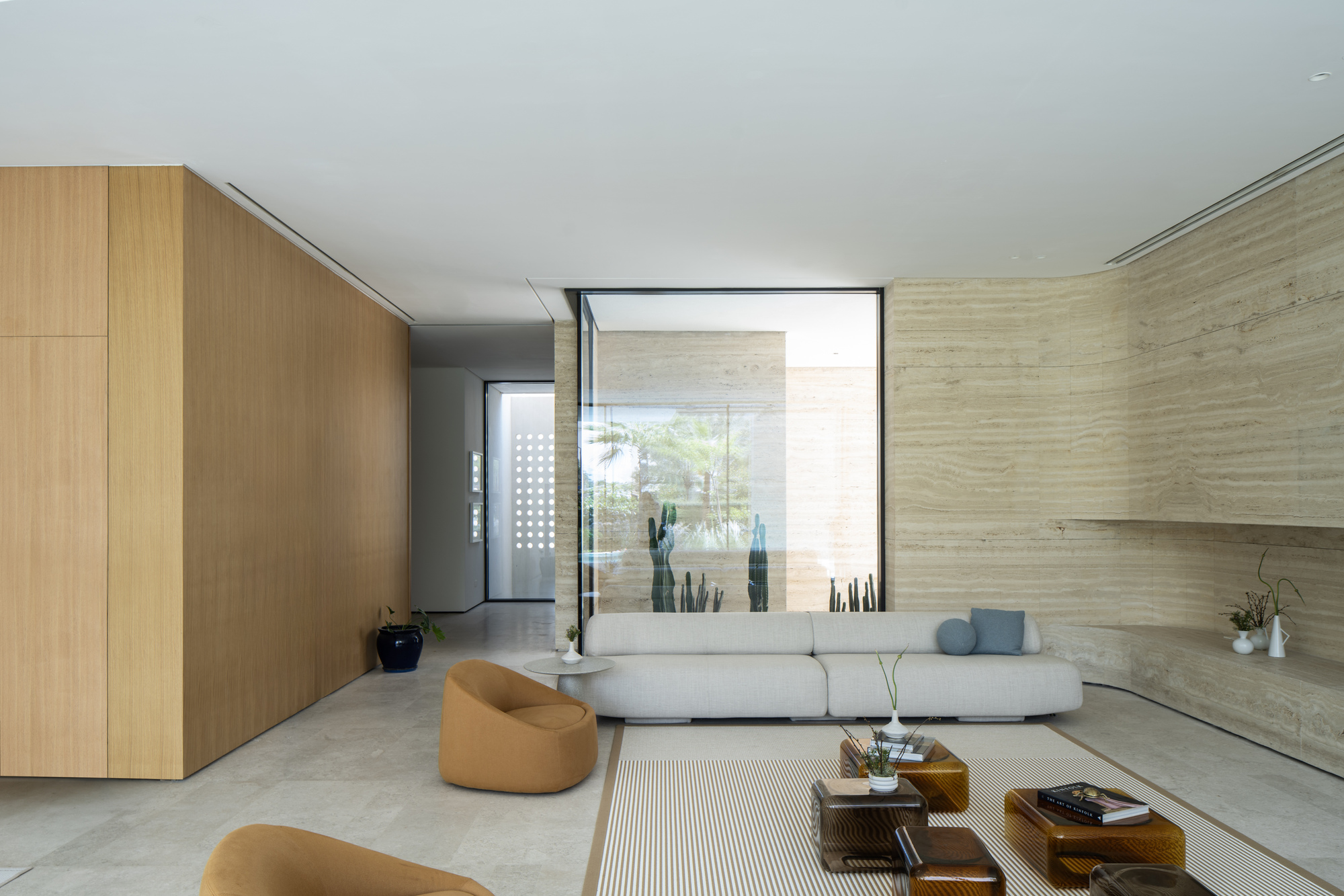 Interior corner with oak paneling and framed window view of travertine wall beyond