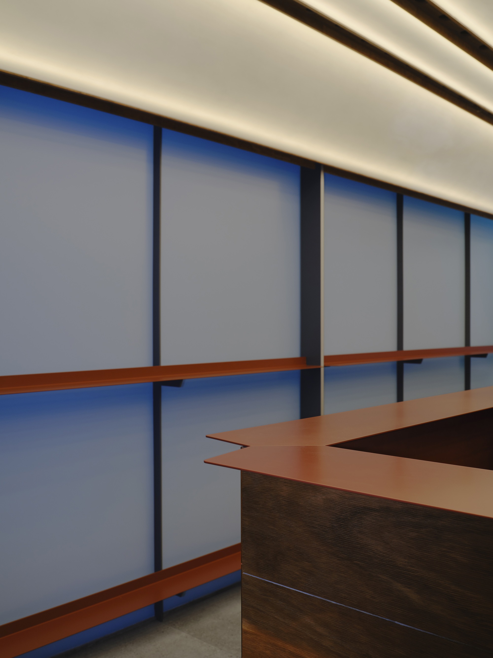Angular copper countertop detail against the panel wall with backlit ceiling above