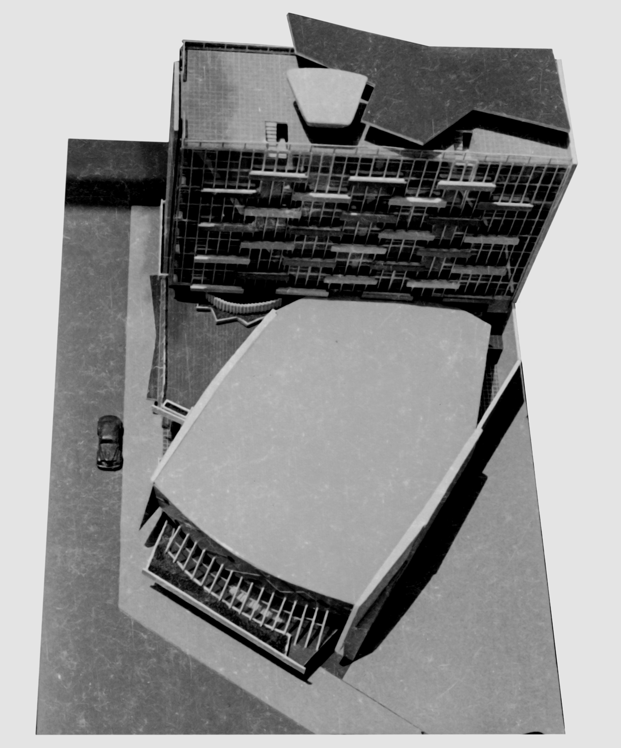 Aerial view of a pentagonal roof canopy over an auditorium with a car parked nearby