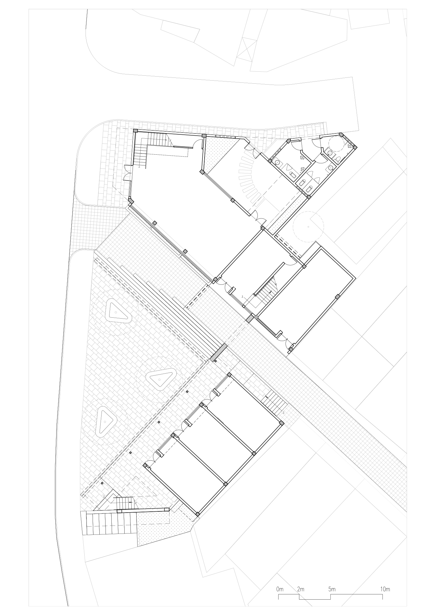 Ground floor plan drawing showing an angular building layout with interconnected rooms and exterior terraces