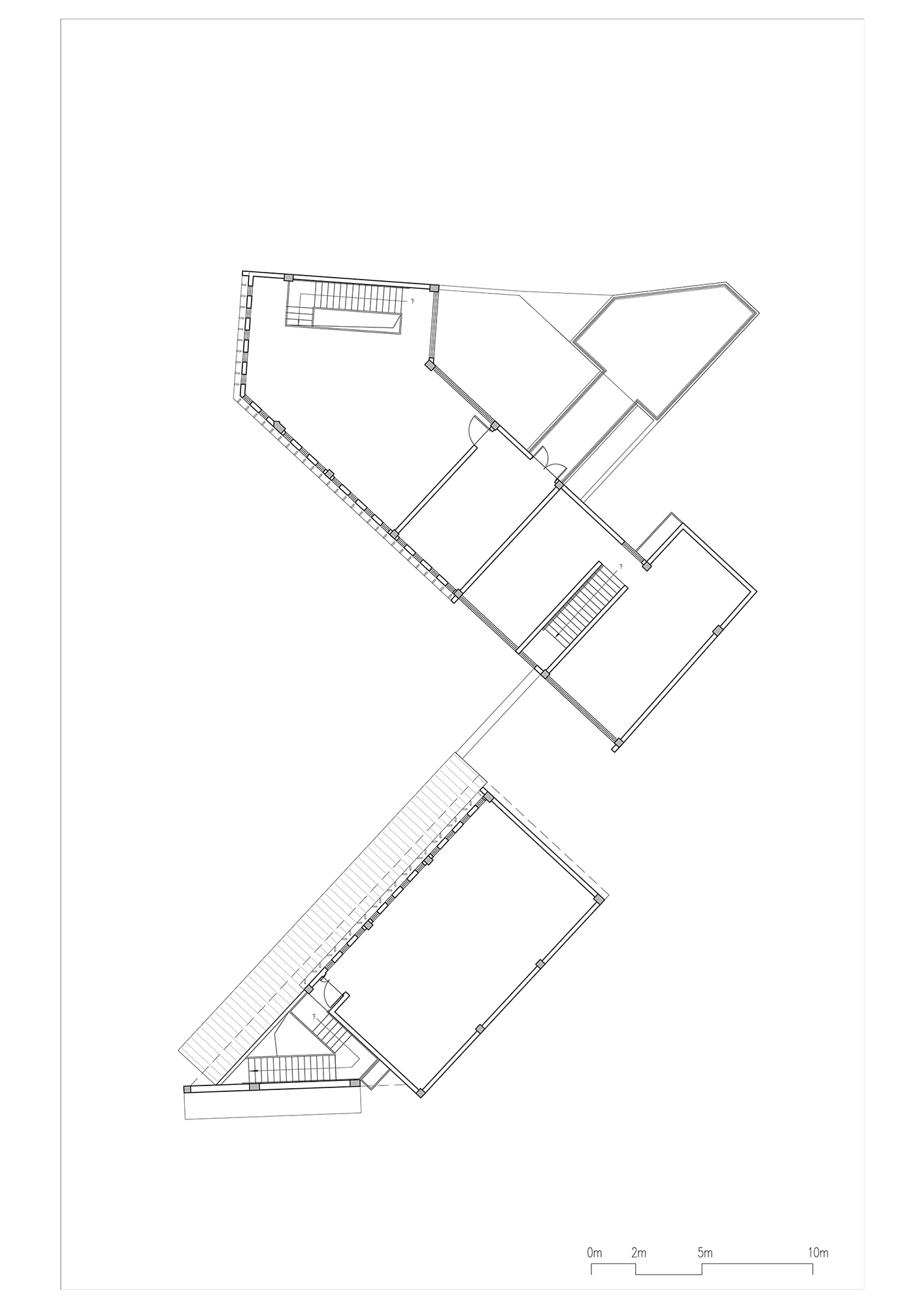 Upper floor plan drawing showing a fragmented building with angled wings and two staircases