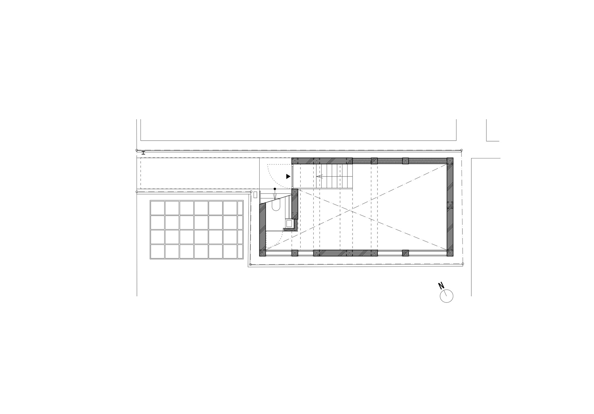 Ground floor plan drawing showing a rectangular concrete volume with stair and toilet, beside a gridded paved or planted area