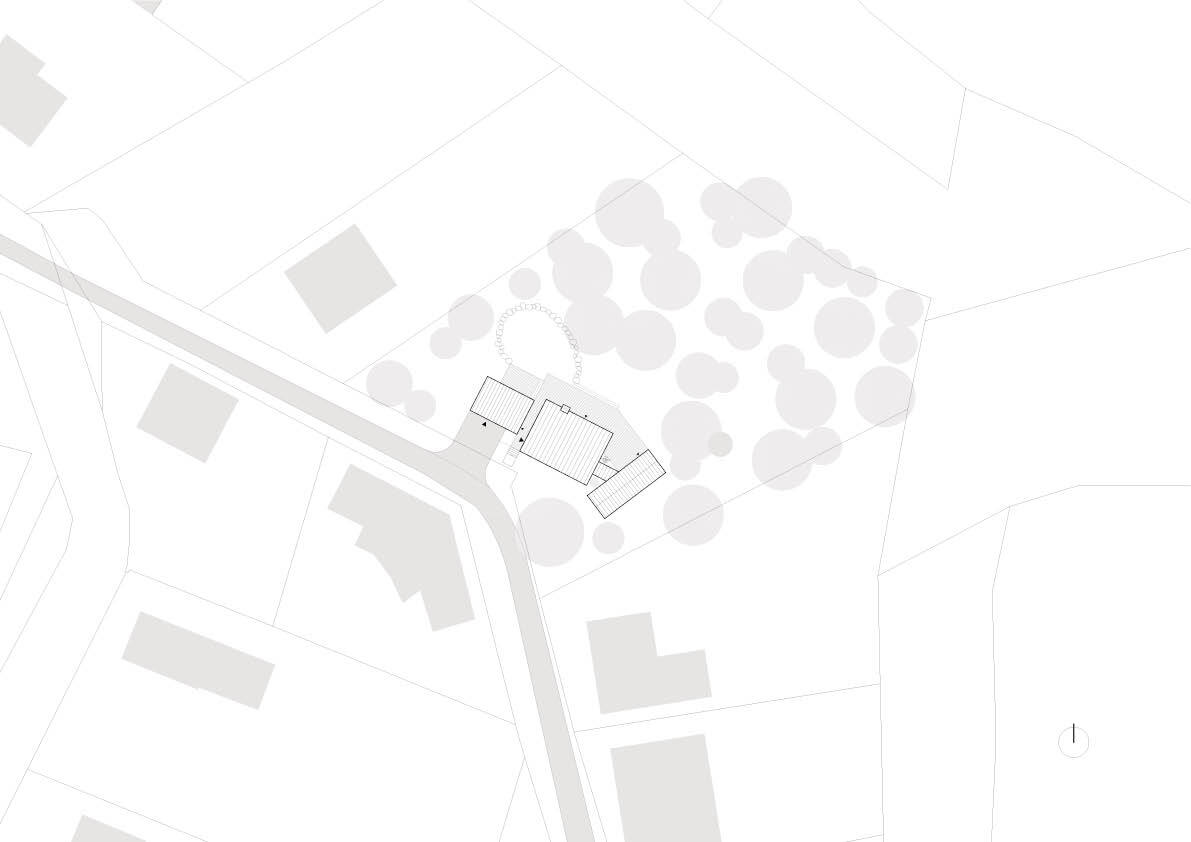 Site plan drawing showing three roofed volumes clustered among tree canopies beside a curving road and surrounding plots with neighbouring buildings