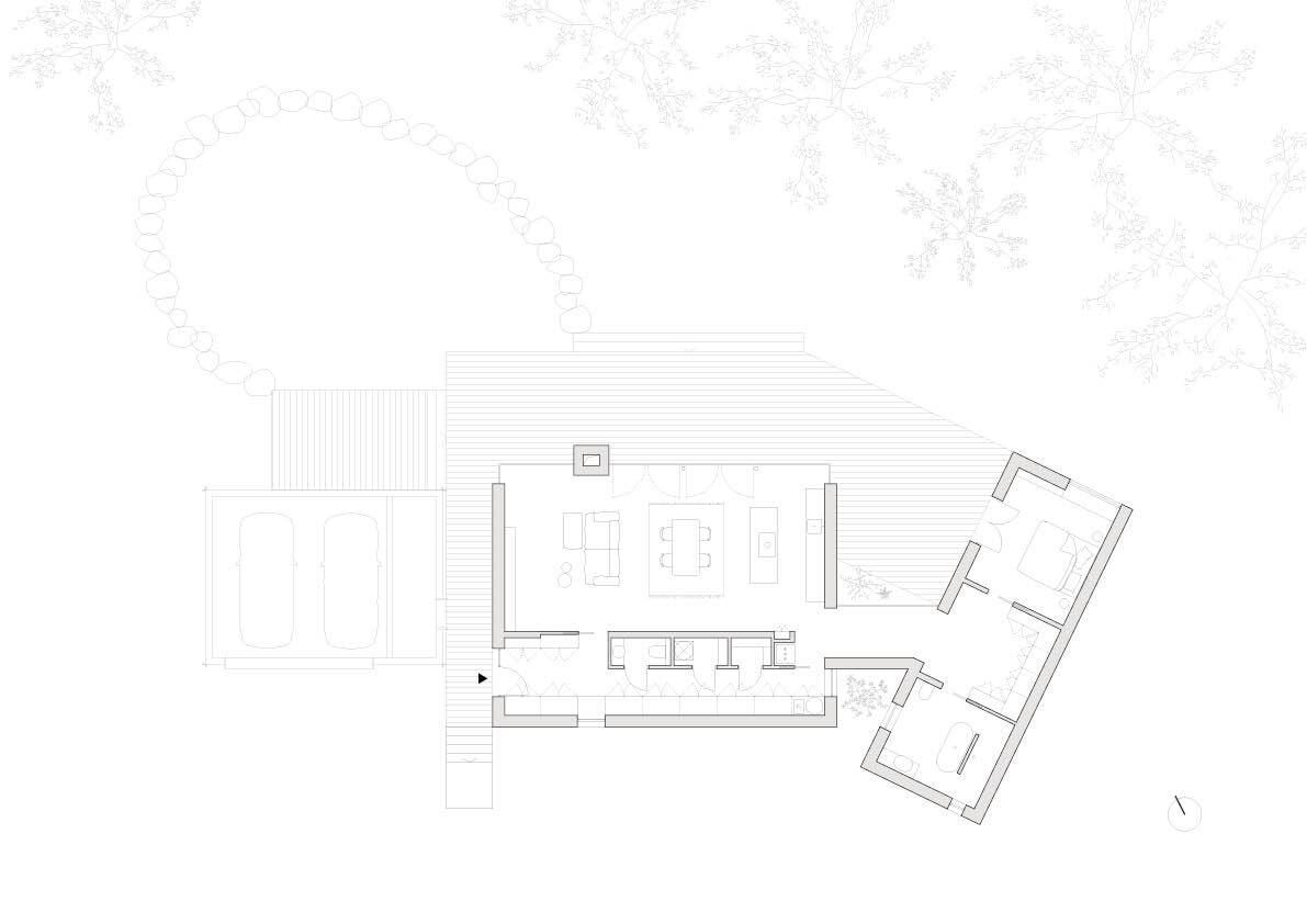 Floor plan drawing showing a long living volume with a fireplace, a two-car garage and an angled bedroom wing, with tree canopies overhead