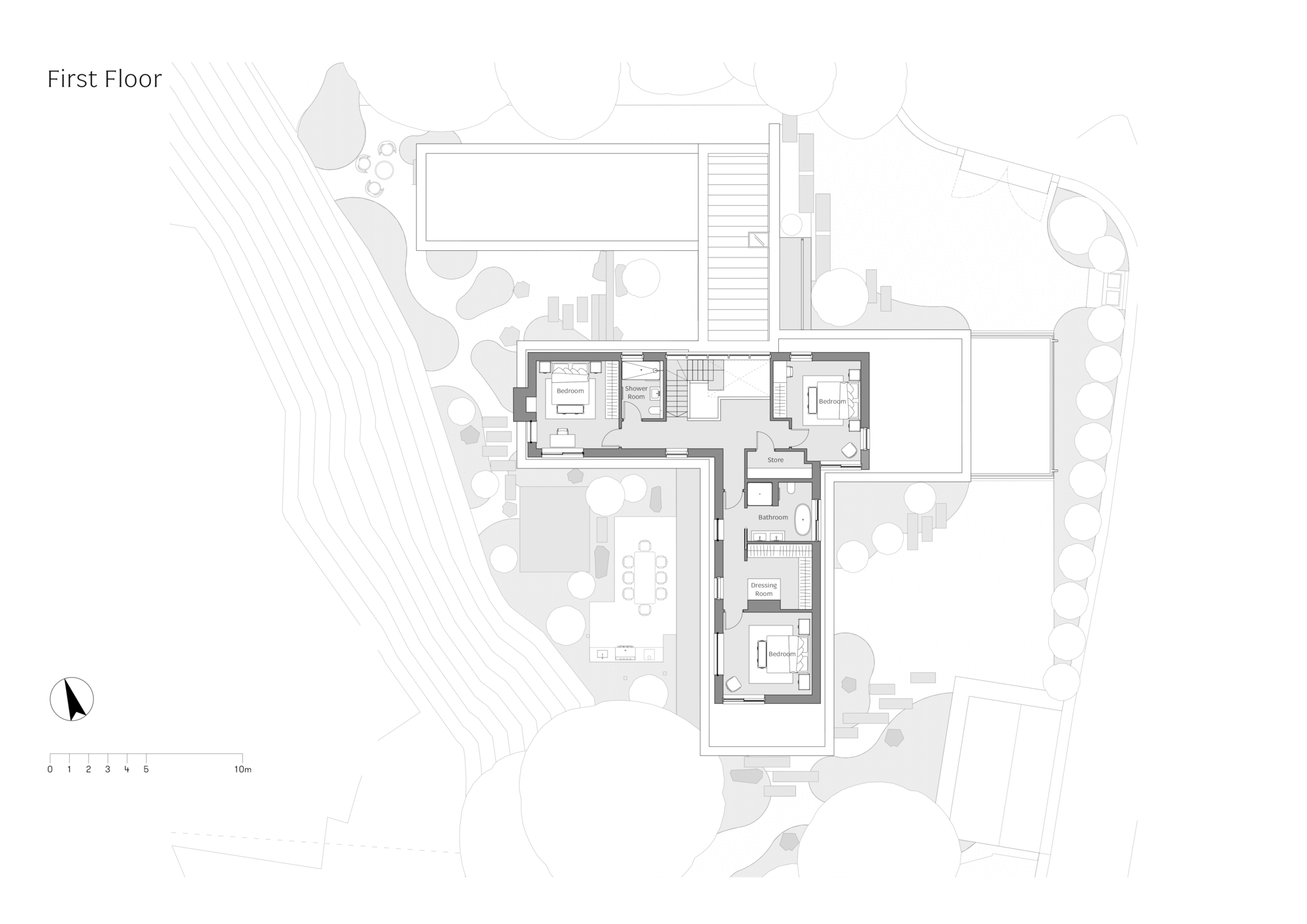First floor plan drawing showing bedrooms, dressing room and bathrooms arranged around a stair in a T-shaped footprint