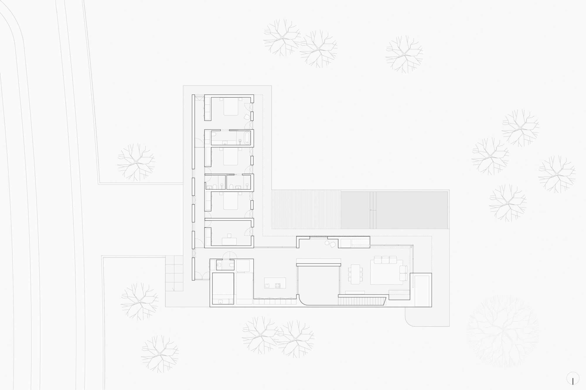 Site plan drawing of an L-shaped house with a row of bedrooms, an open living wing and a terrace among scattered trees