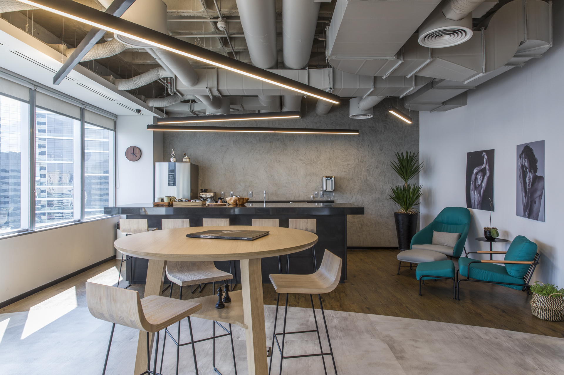 Pantry area with a high round table, wooden stools and a dark counter, sunlight falling across the floor