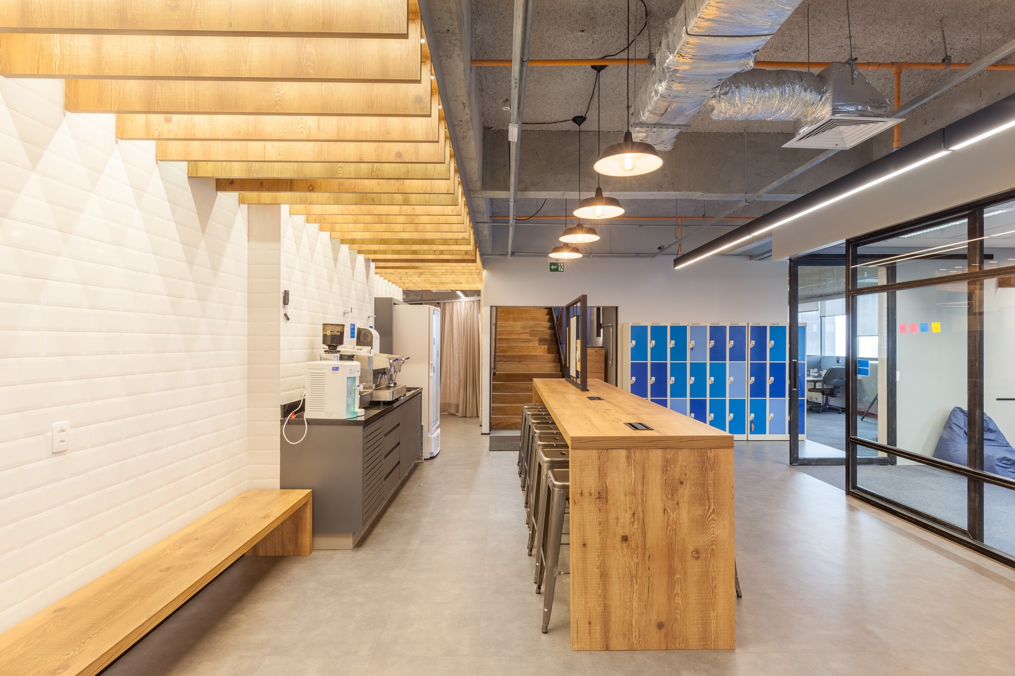 Pantry corridor with white tiled wall, timber bench, slatted wood ceiling and blue lockers at the far end
