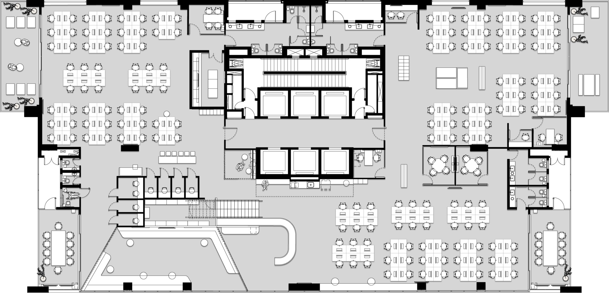 Floor plan drawing of an office level with a central core, rows of desks and a curved stair and lounge area near the bottom