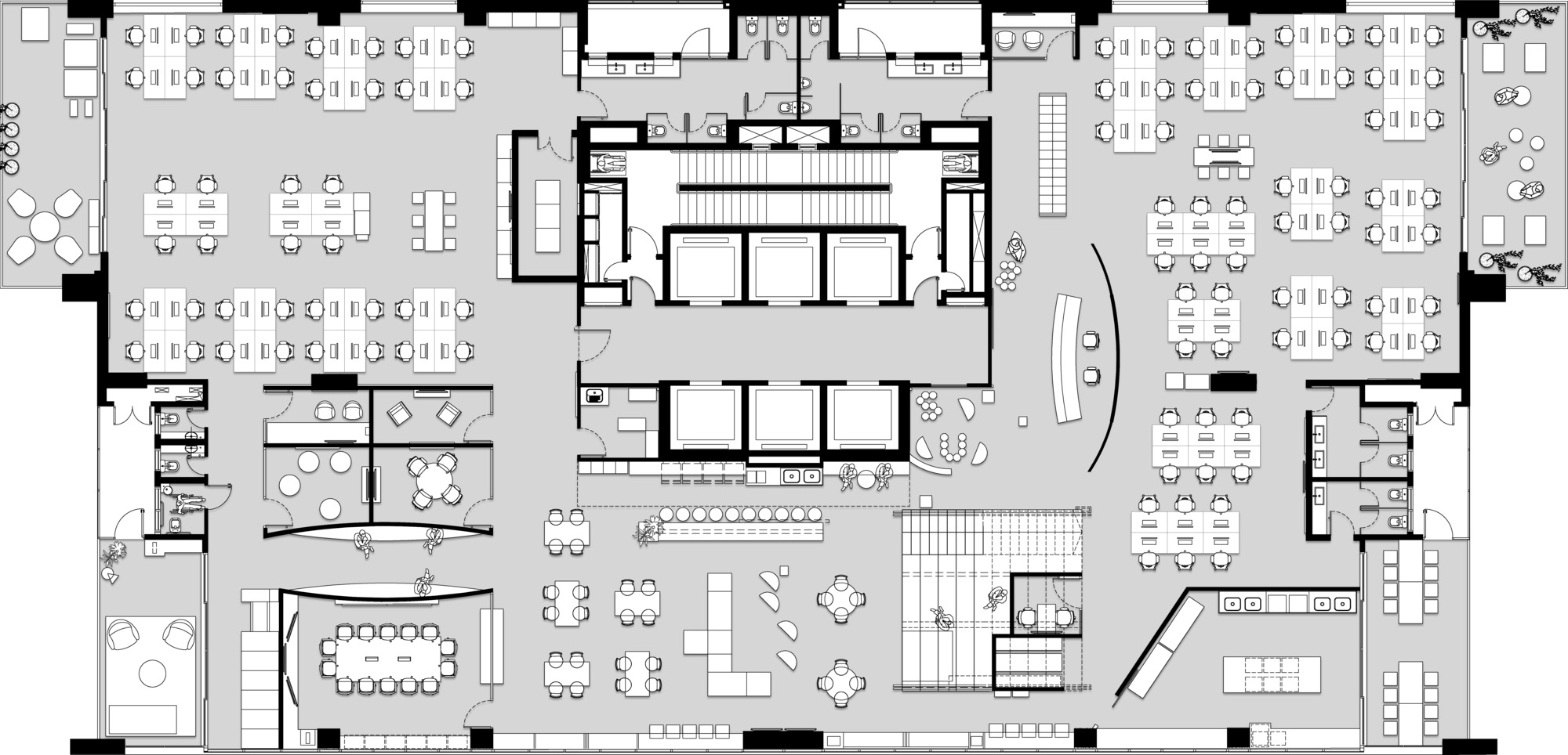 Floor plan drawing showing desk clusters, glazed meeting rooms and a long table beside the central lift core