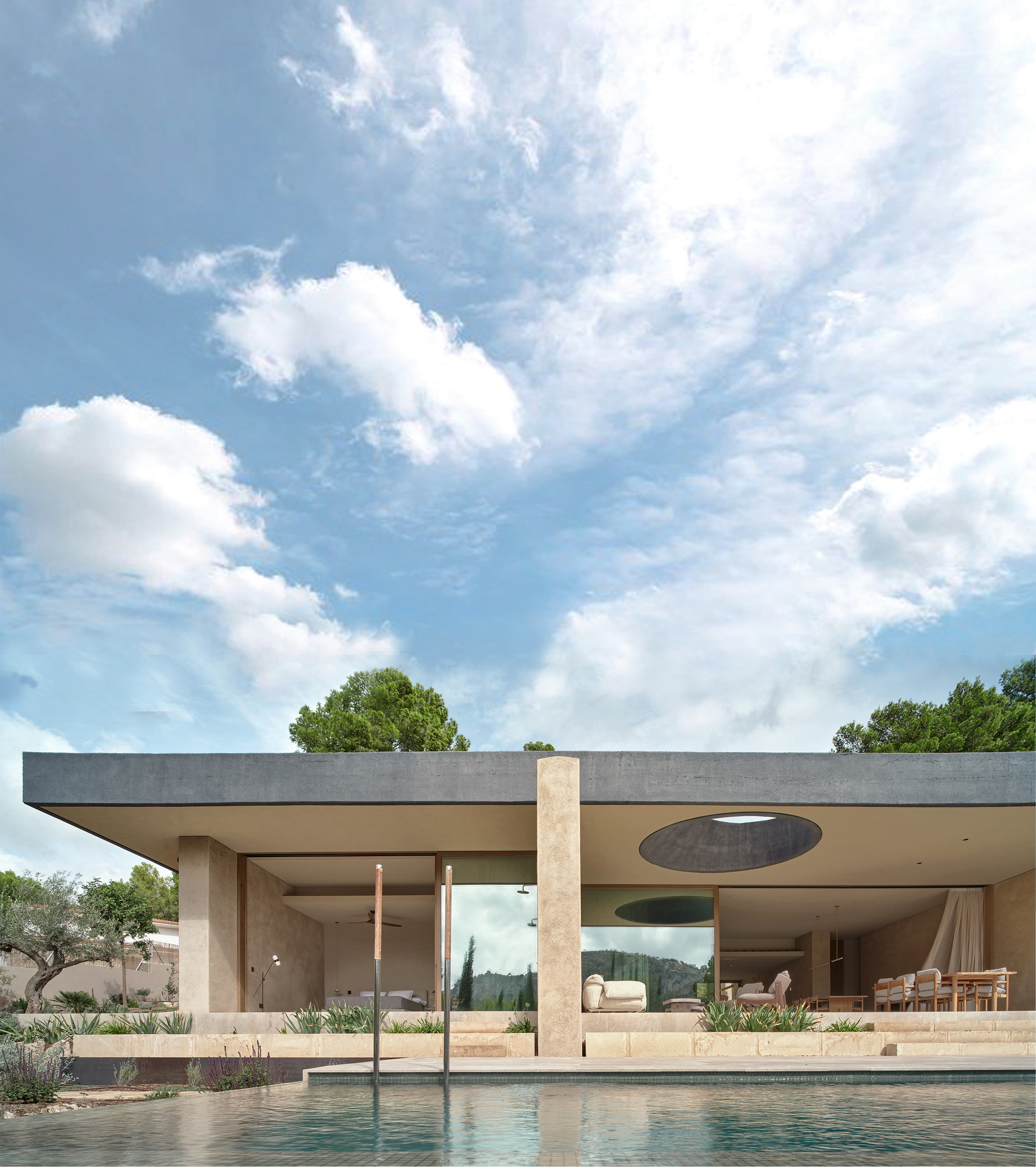 Pool-side view of the flat dark roof slab, stone piers and oval skylight under a sky of scattered clouds