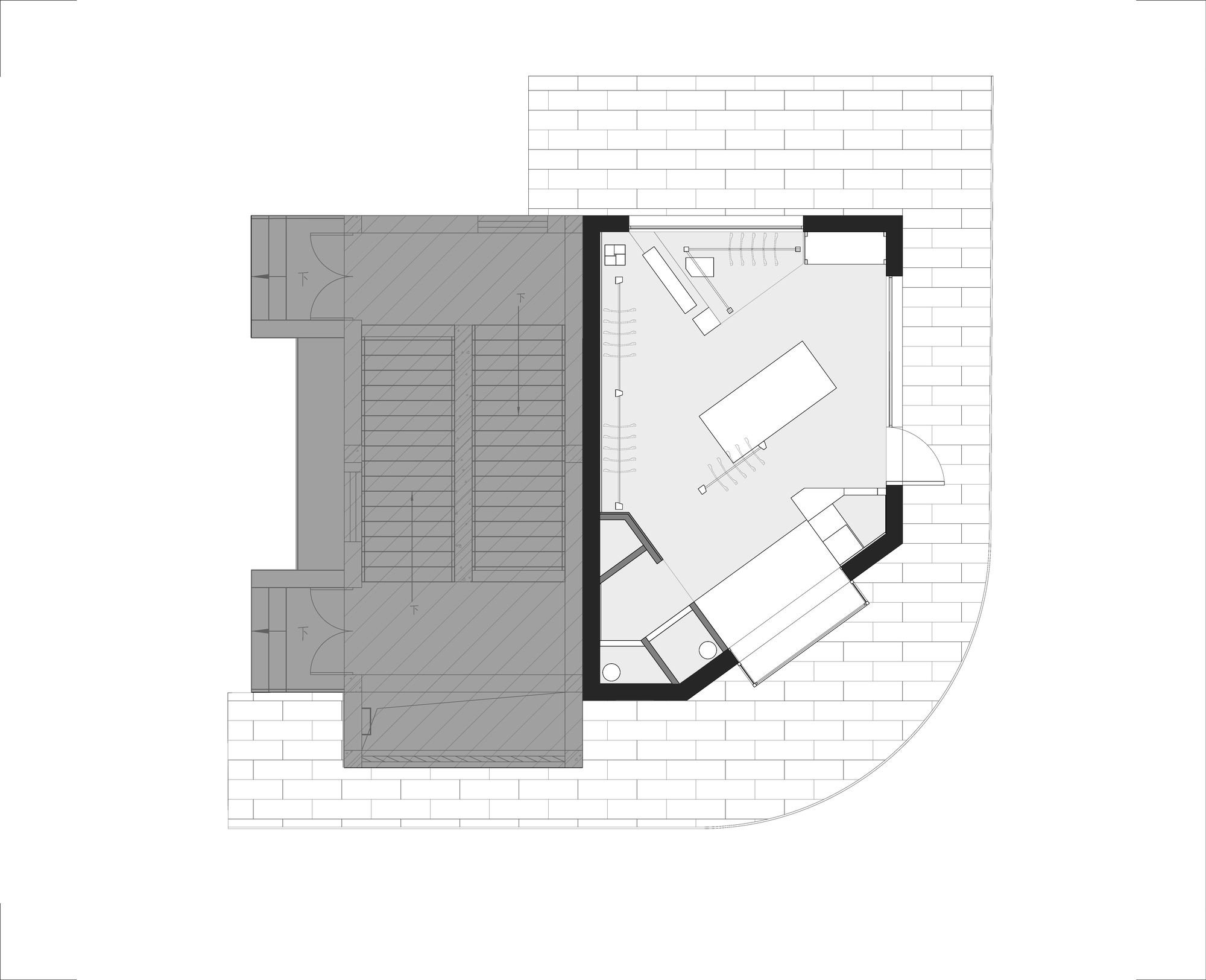 Floor plan drawing of a angular corner shop beside a stair core, with a central display table and curved paved edge