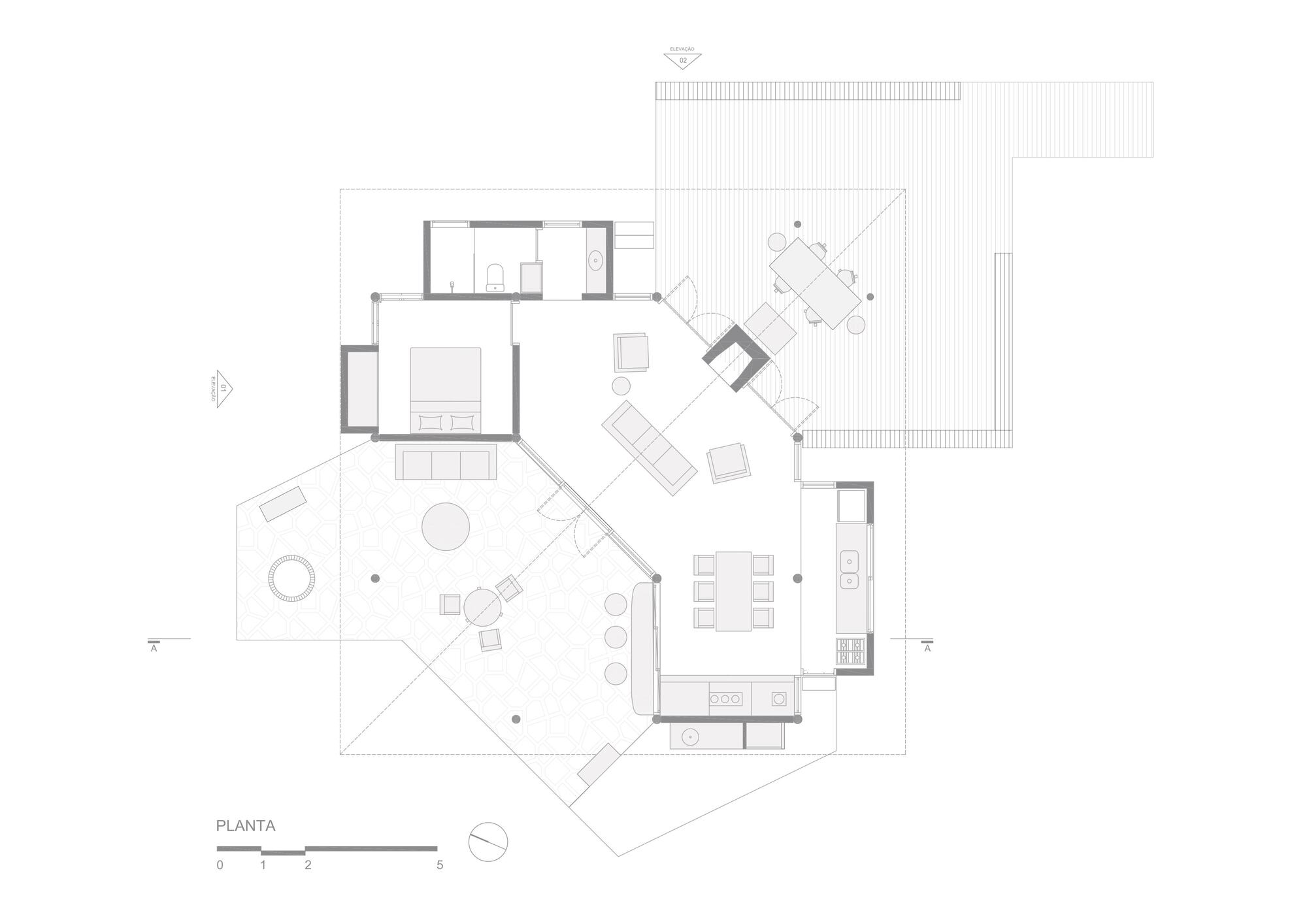 Floor plan drawing showing an angled central living space with bedroom, kitchen, bathroom, a paved terrace and a timber deck