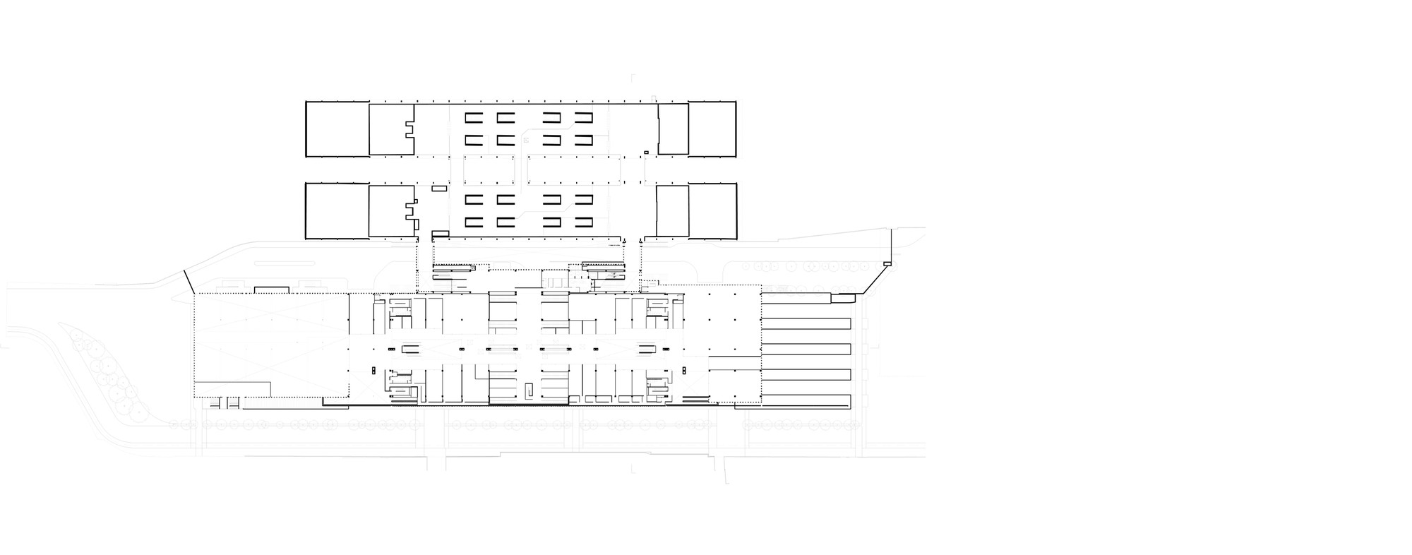 Upper level plan drawing showing two long parallel volumes with end blocks above a wide lower hall with platform fingers at the right