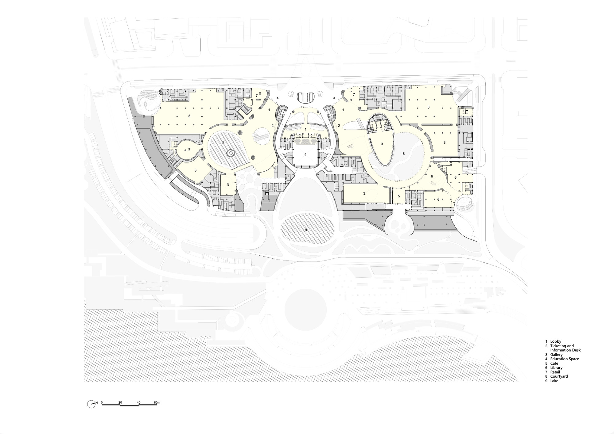 Ground floor plan drawing of two mirrored wings around a central lobby, with a lake and courtyards in the surrounding site