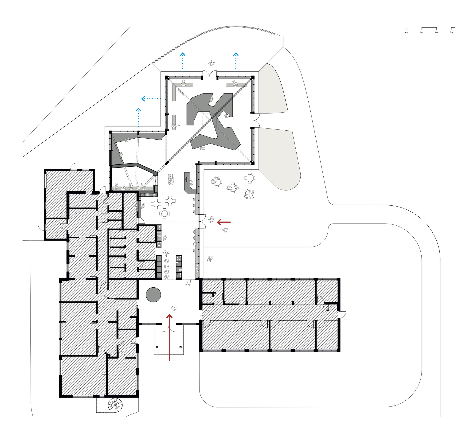 Floor plan drawing showing a main building with wings, a glazed pavilion with angular central displays, entrance arrows, outdoor tables and a curving drive