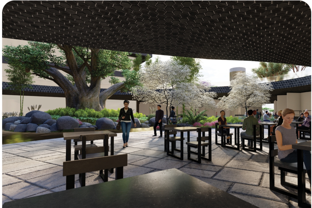 Paved courtyard under a dark hexagon-patterned canopy, with café tables facing boulders, a large old tree and white blossoming trees. Image: Dylan Ramage