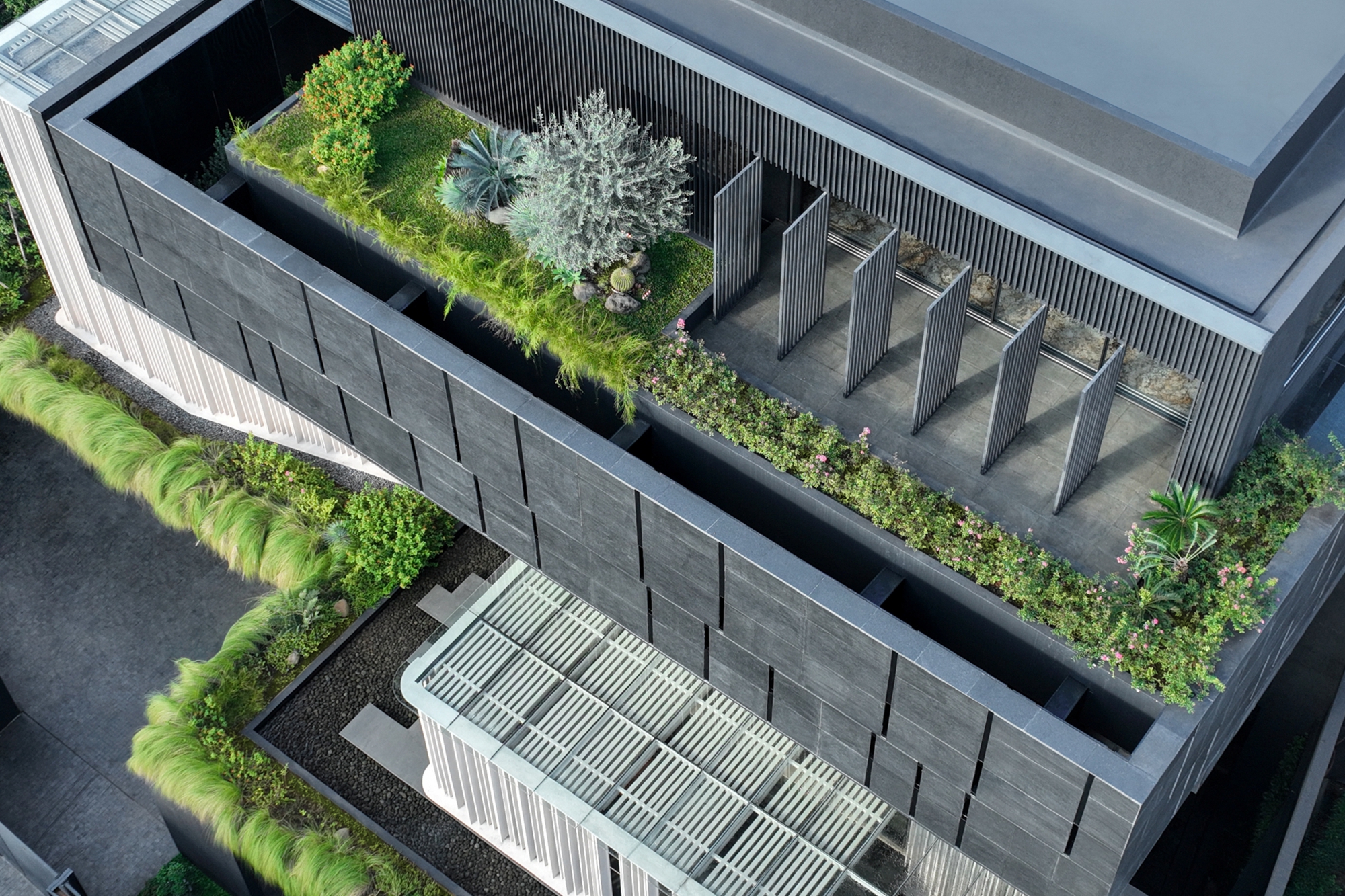 Aerial view of rooftop terraces with planted beds, pivoting vertical louvers and a slatted canopy over the lower level