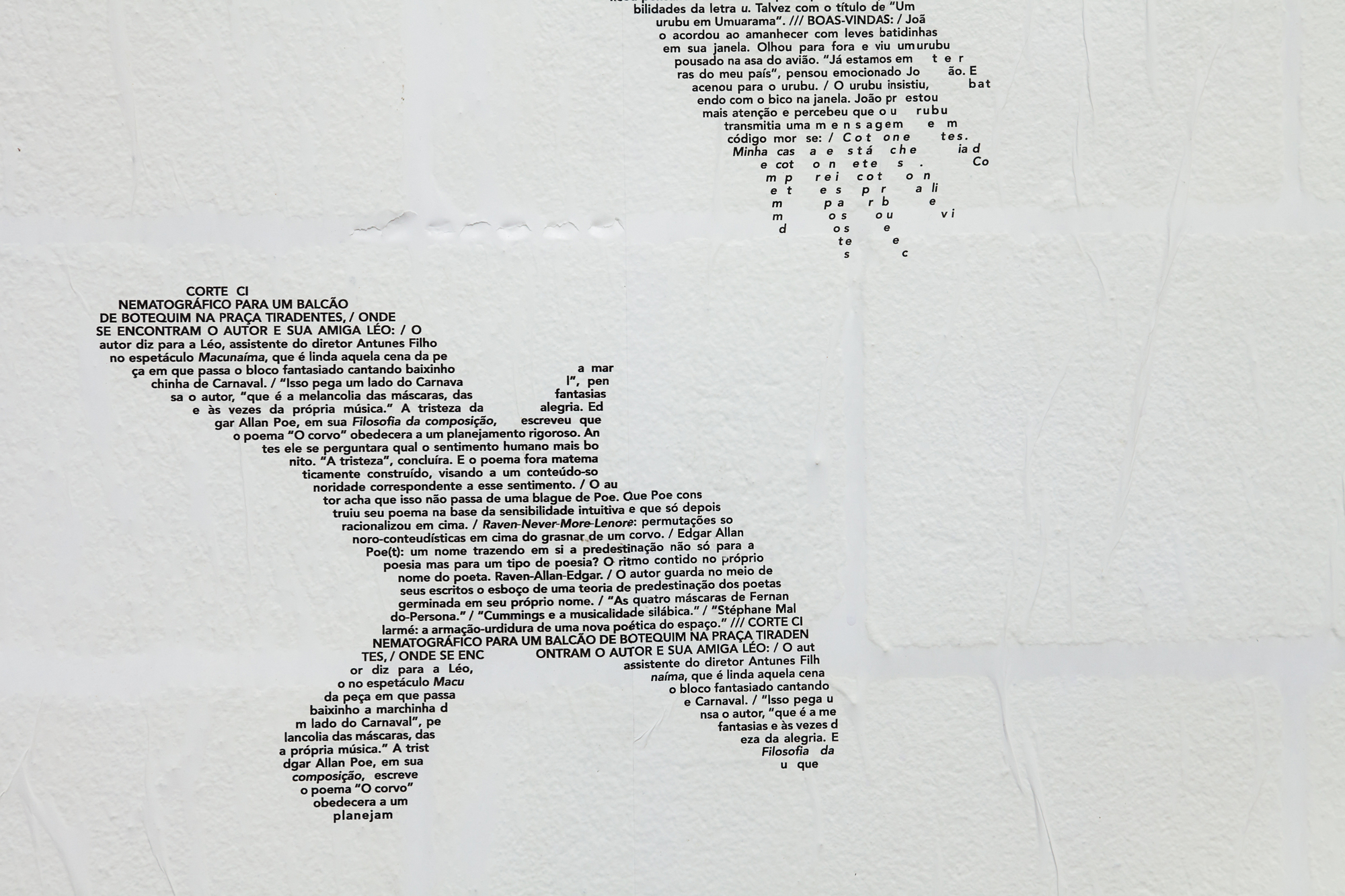 Black text on a white wall arranged in the outline of a bird, with Portuguese passages filling its wings