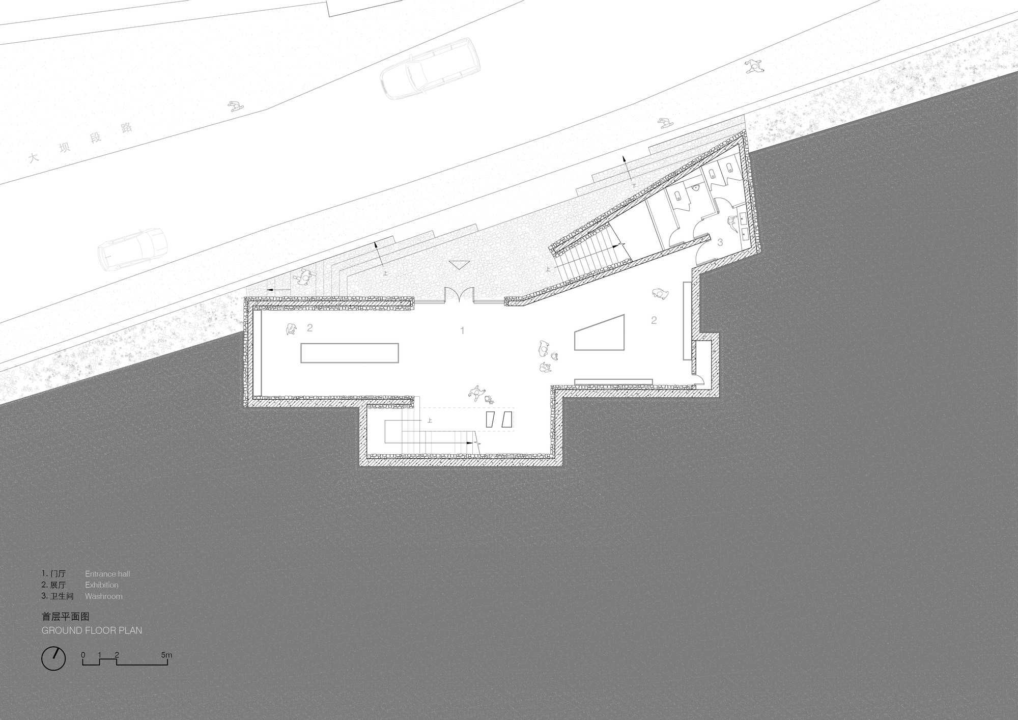 Ground floor plan drawing showing an entrance hall, exhibition spaces and washrooms beside a stepped triangular forecourt along the road
