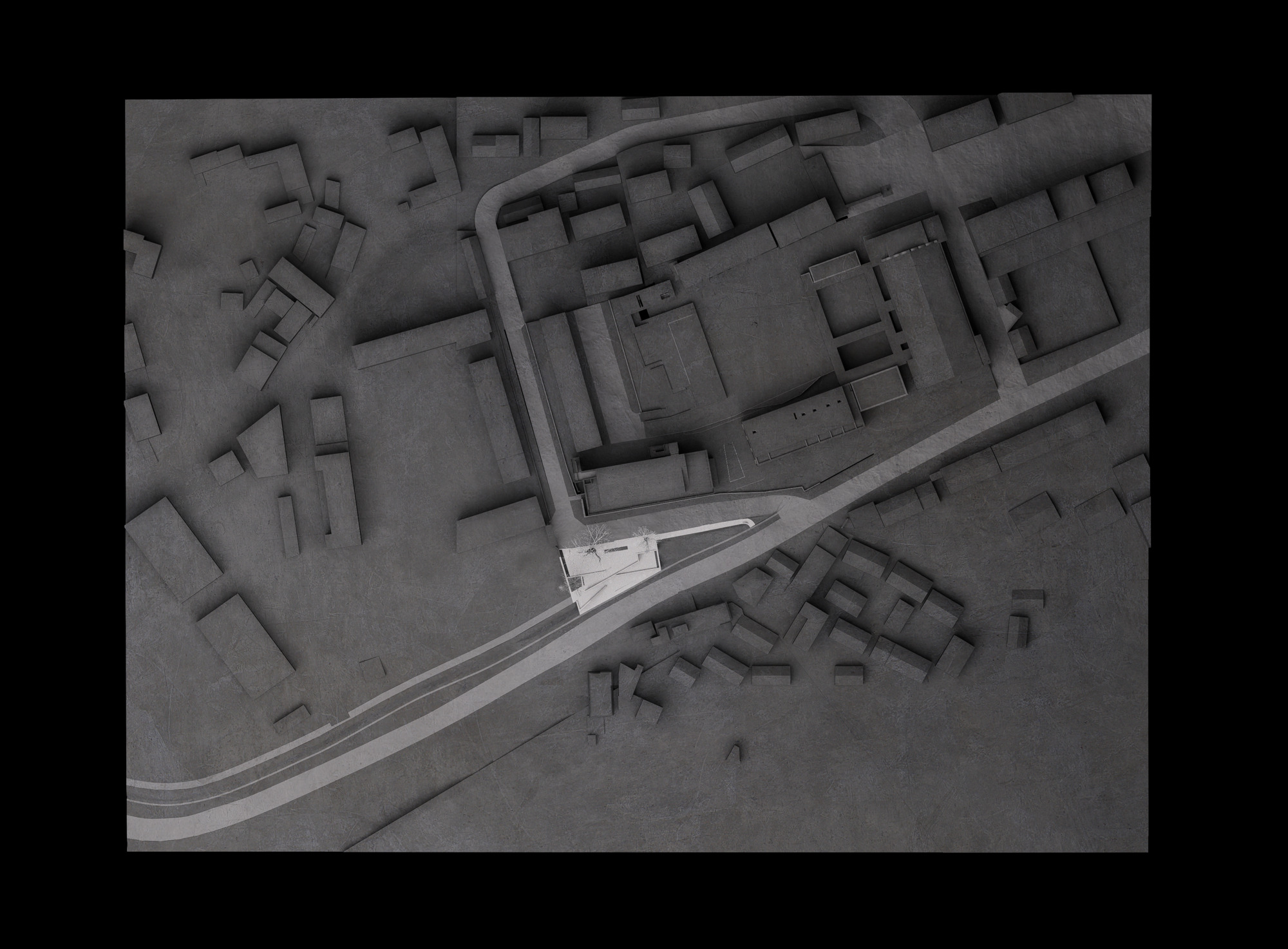 Aerial view of a site model showing a small pale volume wedged beside a curving road among dense grey building blocks