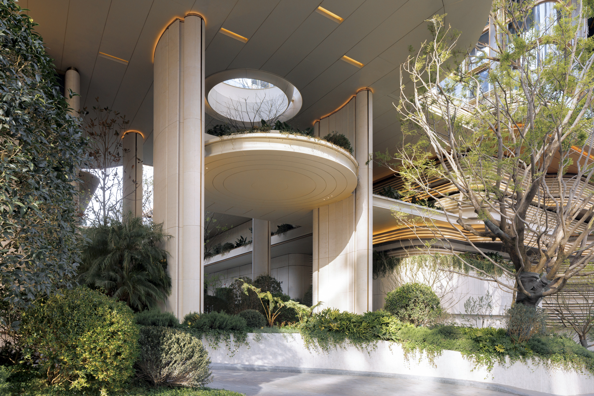 Oval cantilevered planter balcony beneath a circular skylight, flanked by cylindrical stone columns and a budding tree in low sun