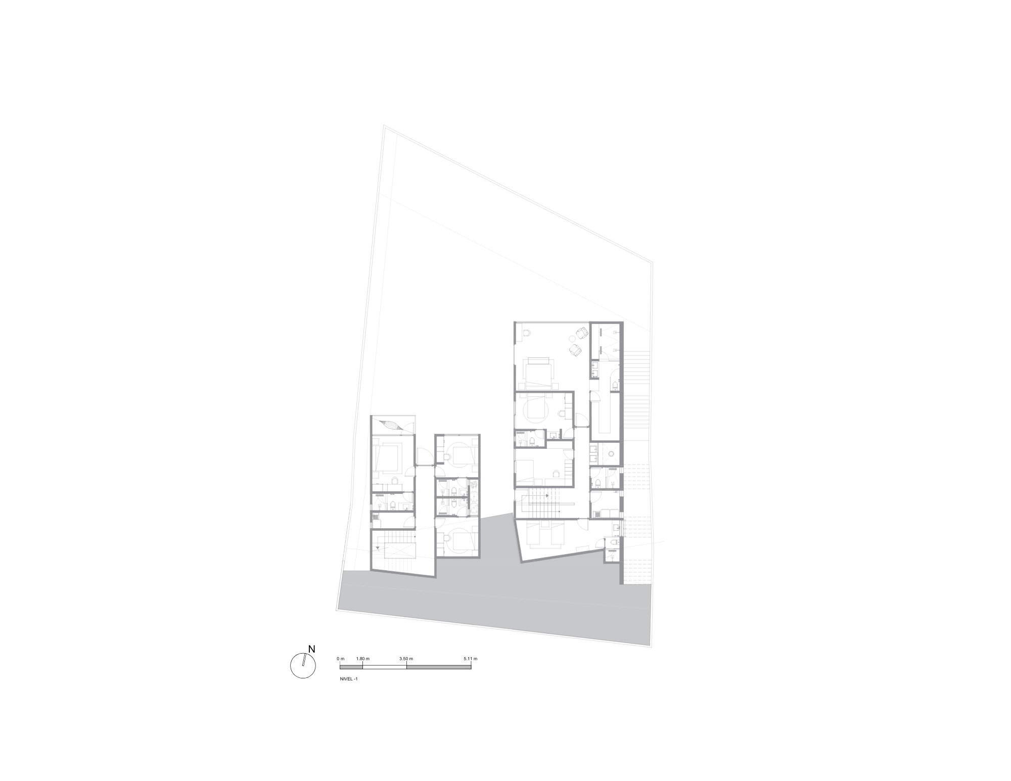 Floor plan drawing of the lower level showing two clusters of bedrooms and bathrooms on an angular site with a shaded terrace