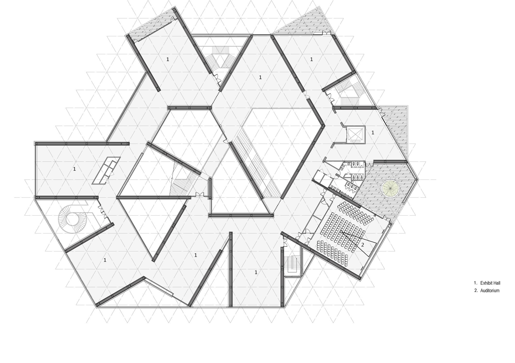 Upper floor plan drawing on a triangular grid showing exhibit halls around a central void, with an auditorium and tiered seating at right
