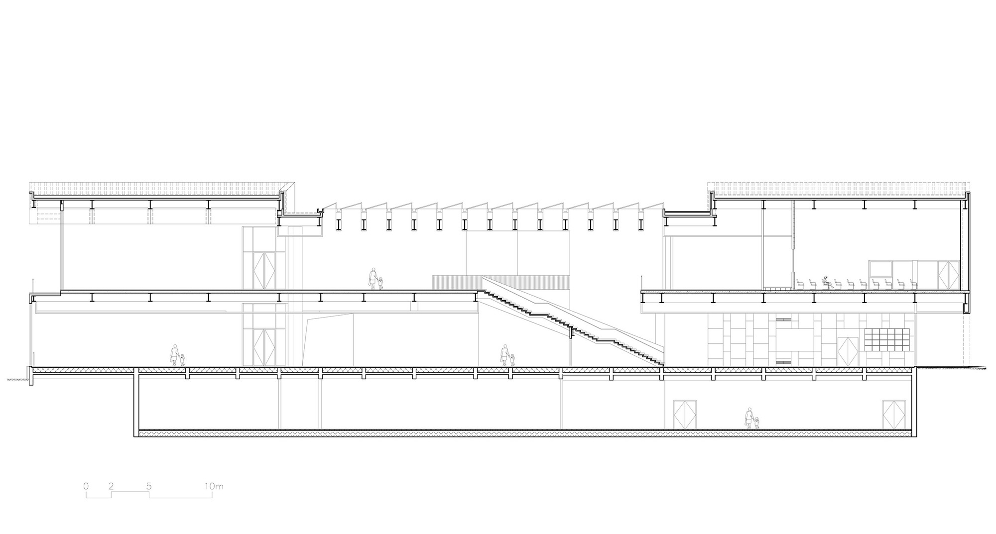 Long section drawing cutting through a basement, two upper floors, a sawtooth skylight roof and a diagonal staircase with small figures for scale