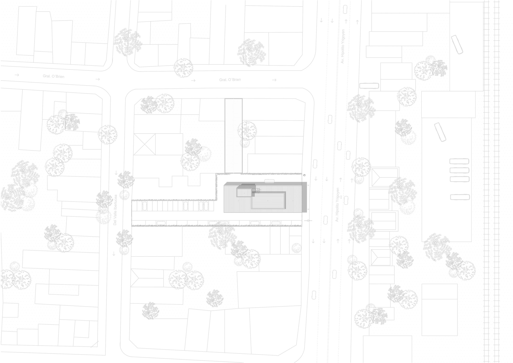Site plan drawing showing a long narrow building on a block between streets, with surrounding lots, trees and a wide avenue