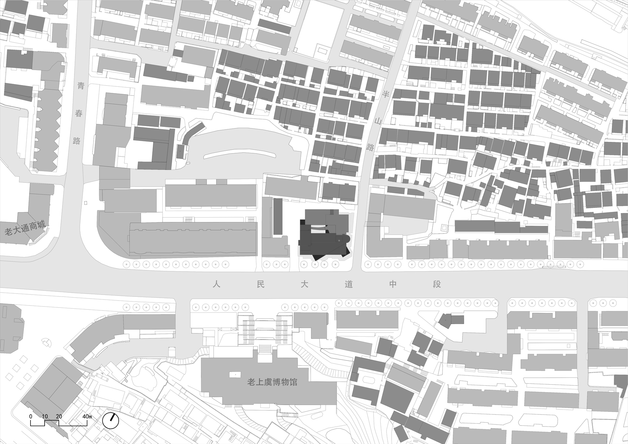 Site plan drawing showing the building footprint in dark grey among dense blocks along a main avenue, with a scale bar