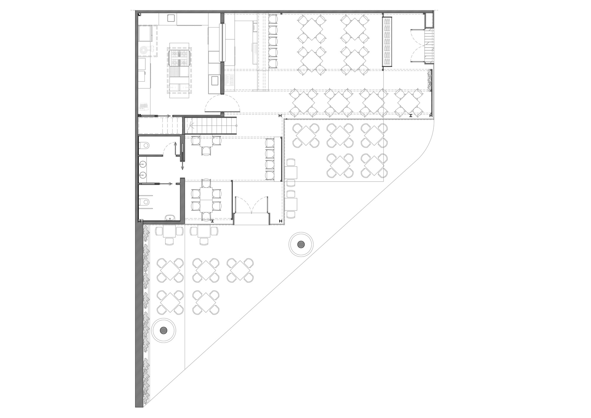 Ground floor plan drawing of a triangular site showing kitchen, restrooms, stair and dining tables across interior rooms and an outdoor terrace