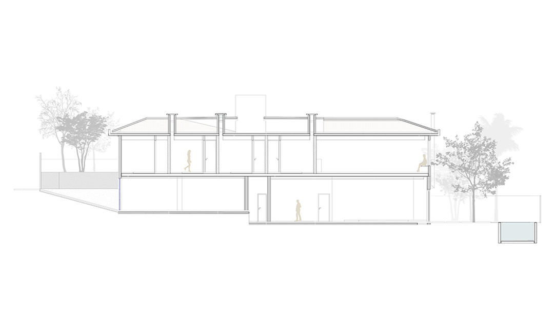 Section drawing of a two-level house with hipped roof and skylights, with small figures standing inside and trees on either side
