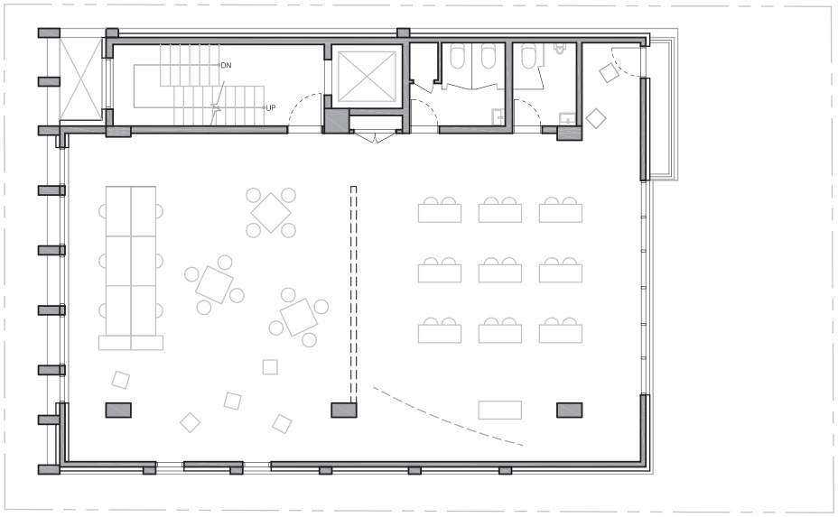 Floor plan drawing of an open upper floor with tables and desks, a stair and elevator core, restrooms and perimeter columns