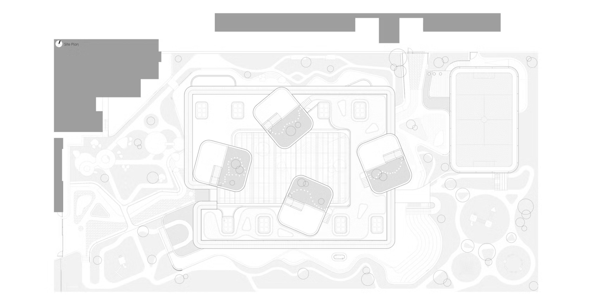Site plan drawing showing four tilted roof volumes over a rectangular footprint, with a sports pitch and winding garden paths around it