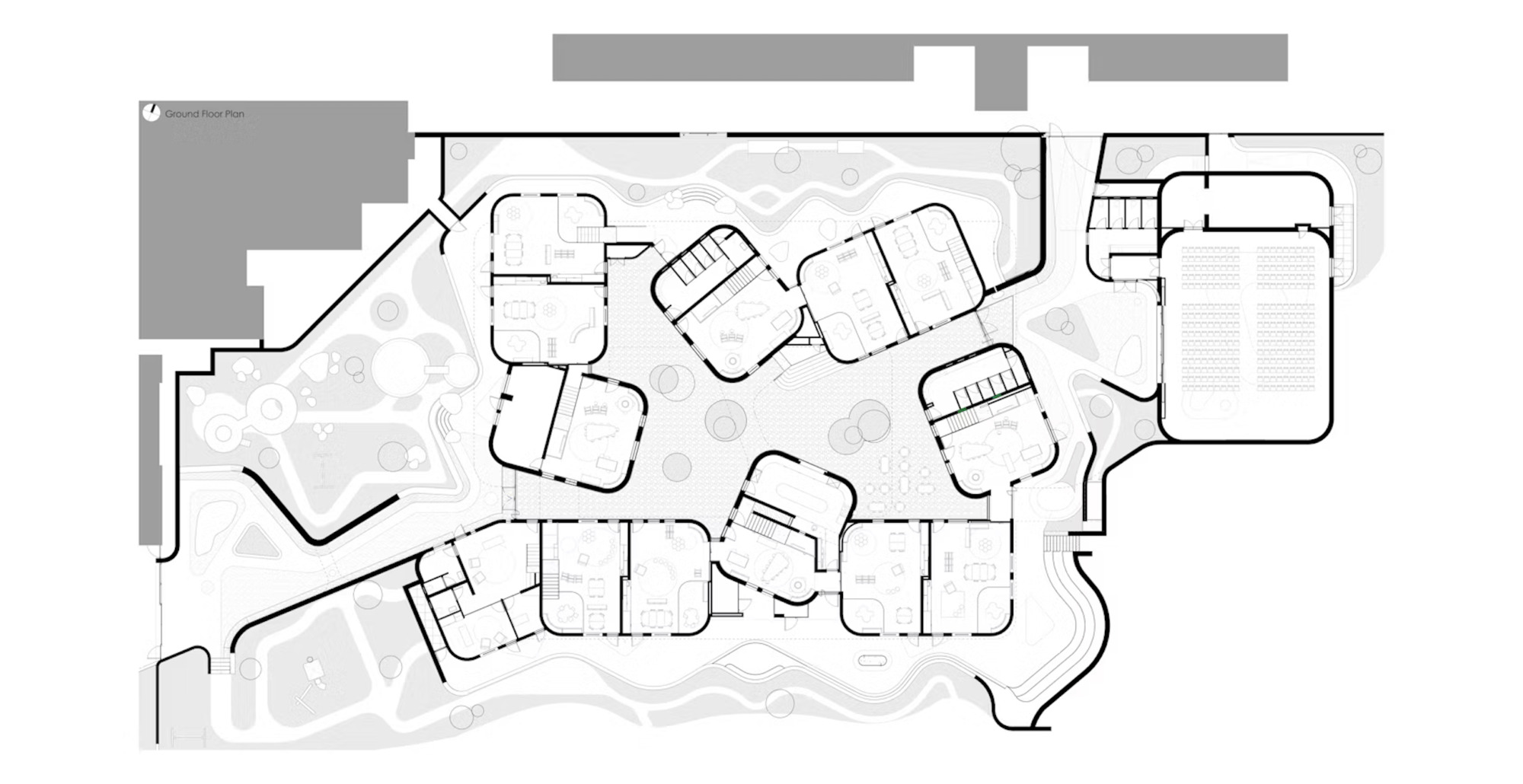 Ground floor plan drawing showing clustered rounded rooms around a central open court, with an auditorium at the right edge