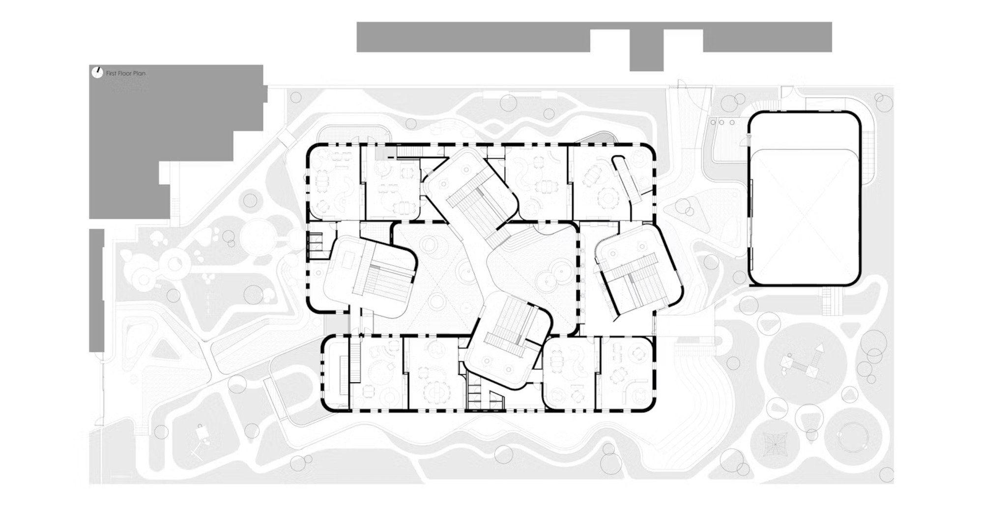 First floor plan drawing showing a rectangular perimeter of rooms with four tilted stair volumes and a separate hall at right