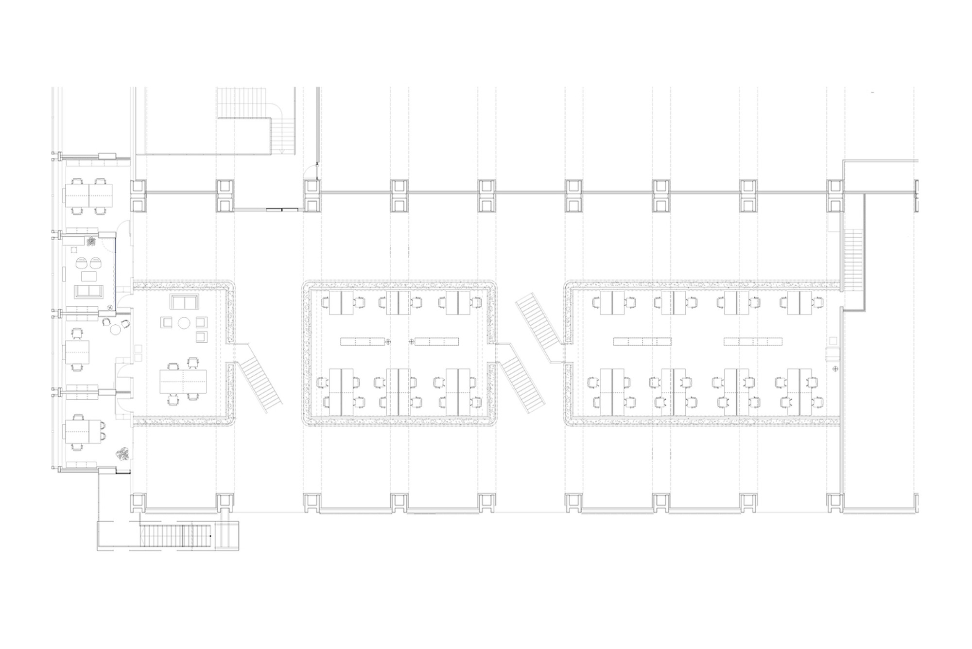 Upper floor plan drawing showing two enclosed desk volumes with workstations, plus a lounge and meeting area at the left end