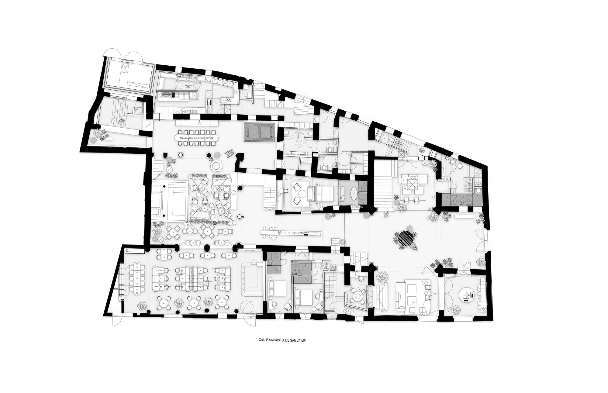 Ground floor plan drawing showing dining tables, lounge furniture, small bedrooms and a central courtyard inside thick irregular masonry walls
