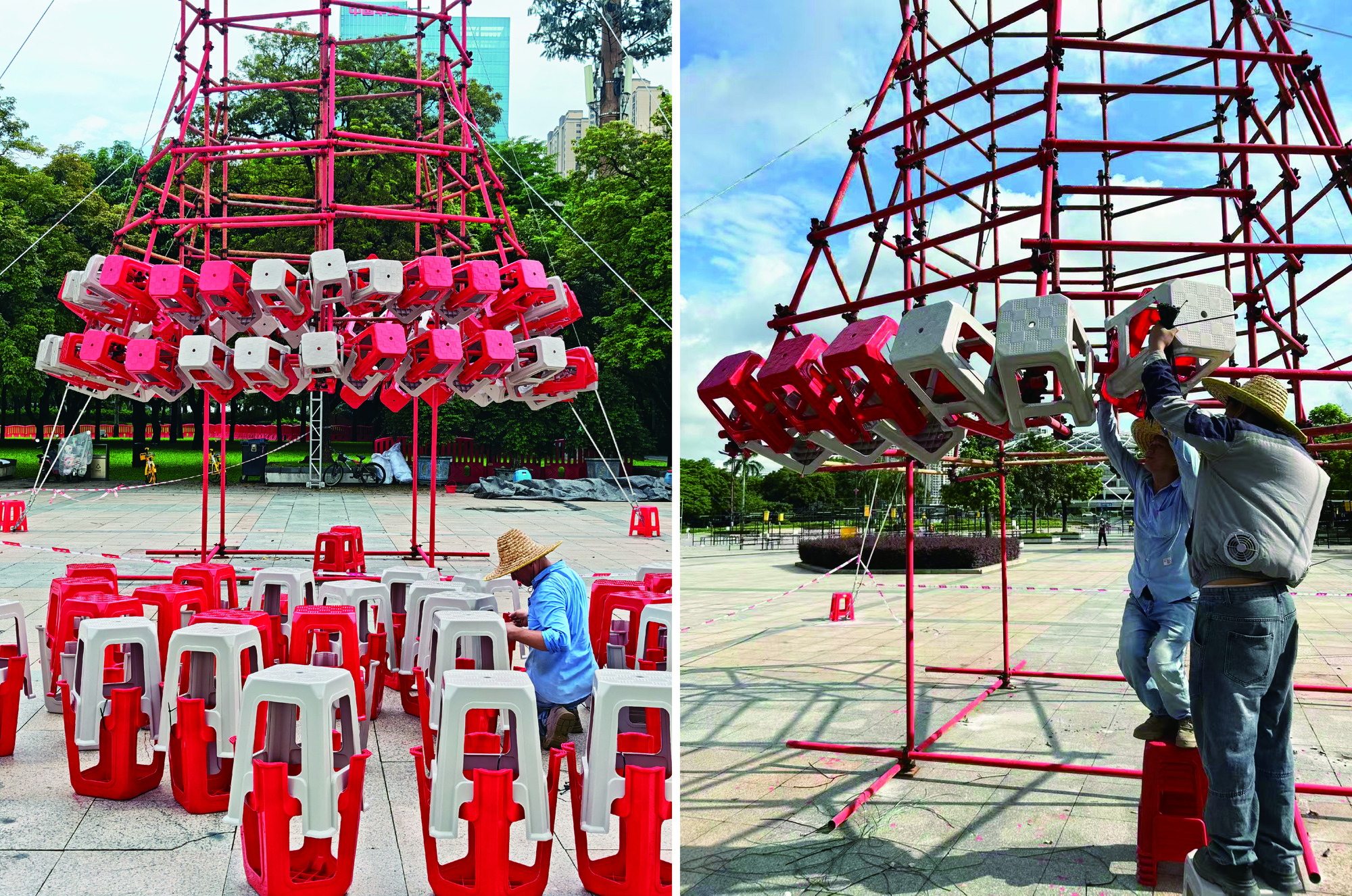 Workers in straw hats stack red and white plastic stools onto a red scaffold frame on a paved plaza under blue sky