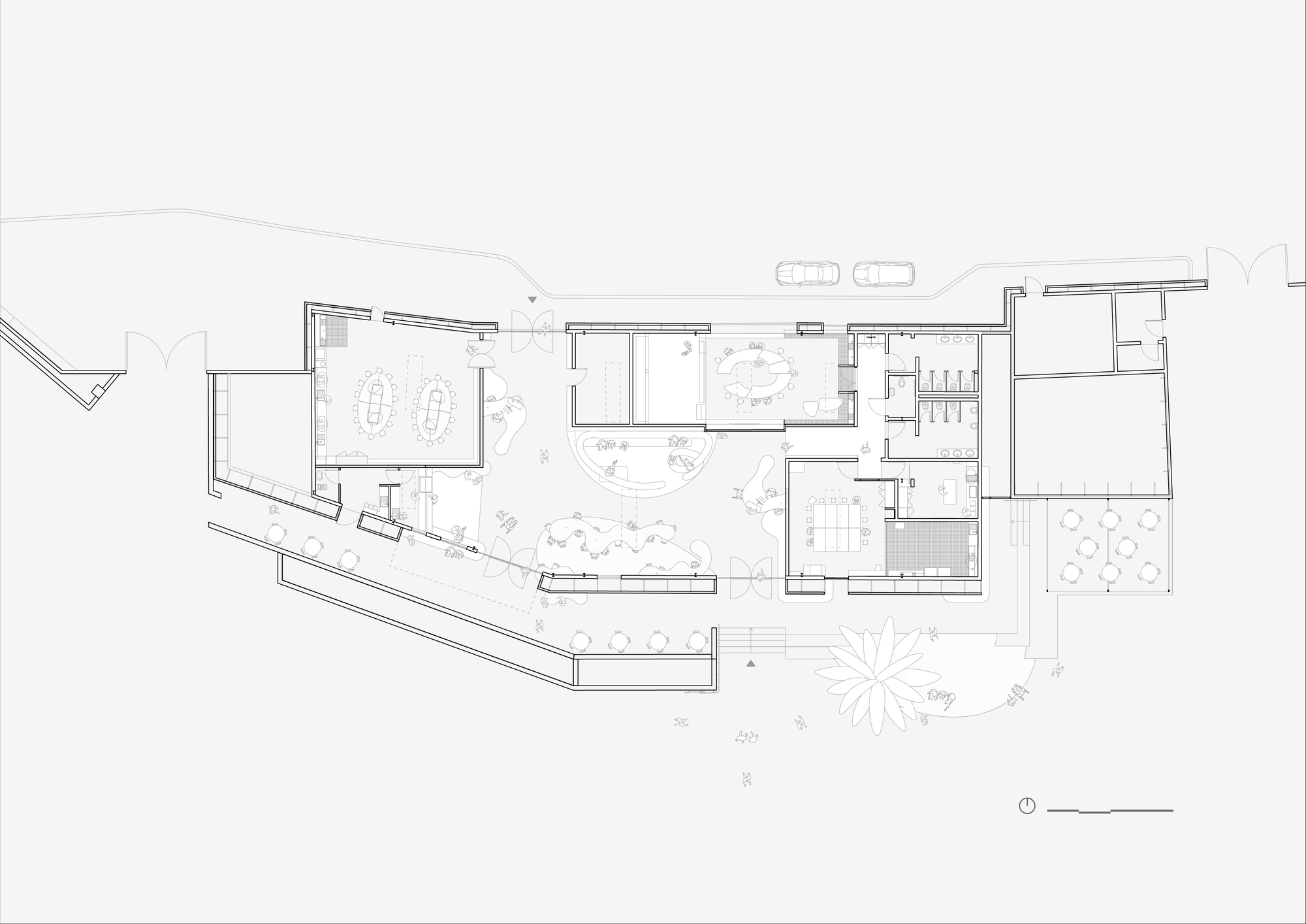 Floor plan drawing showing an irregular ground-level layout with meeting rooms, a curved central counter, restrooms, an outdoor seating terrace and a palm-shape