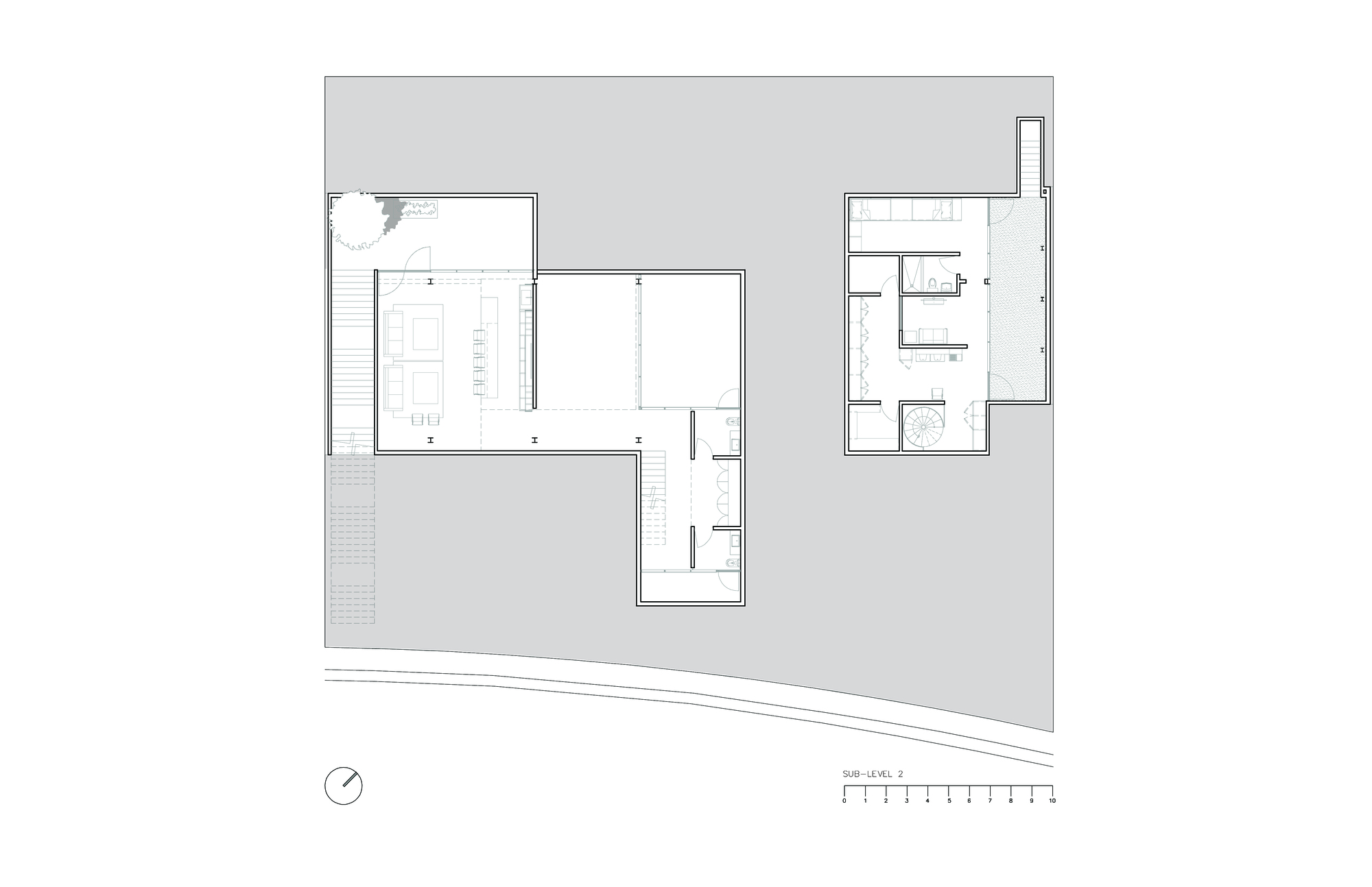 Floor plan drawing of a sub-level showing two separate volumes with living areas, bathrooms and a scale bar