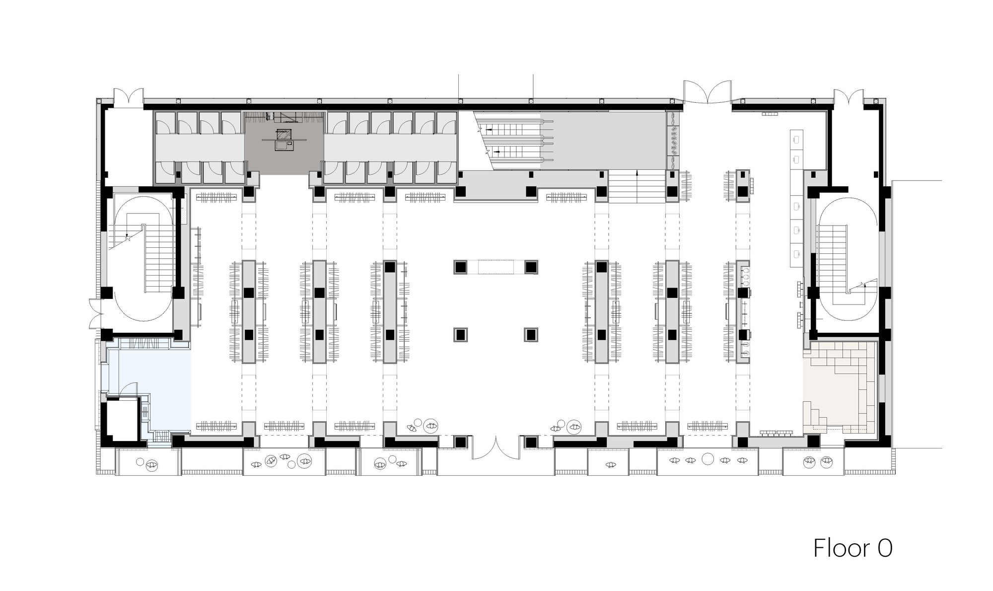 Ground floor plan drawing showing a columned open retail hall, oval stair cores at both ends and a central entrance