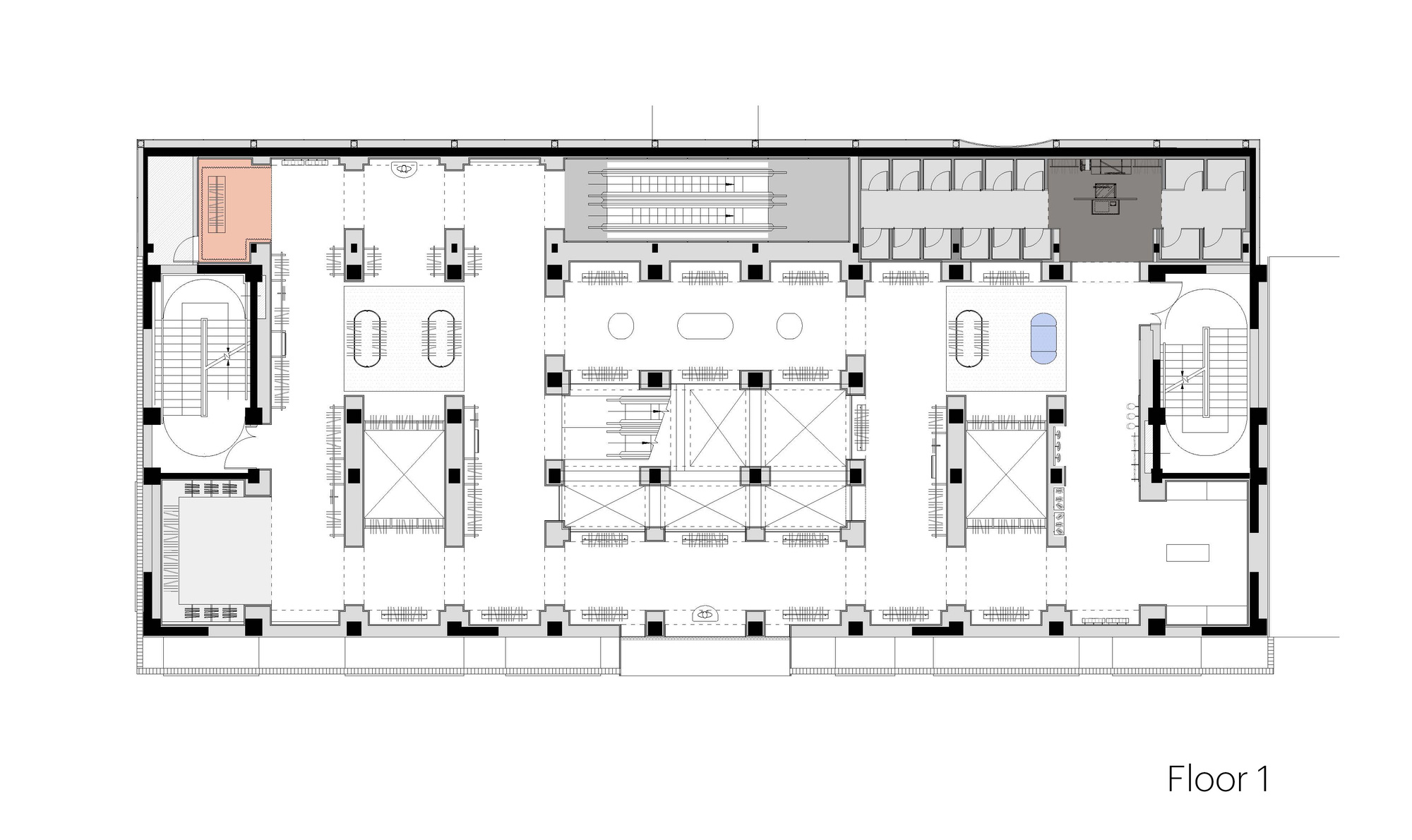 First floor plan drawing showing escalators, restrooms, two oval stair cores and display fixtures arranged around a central void